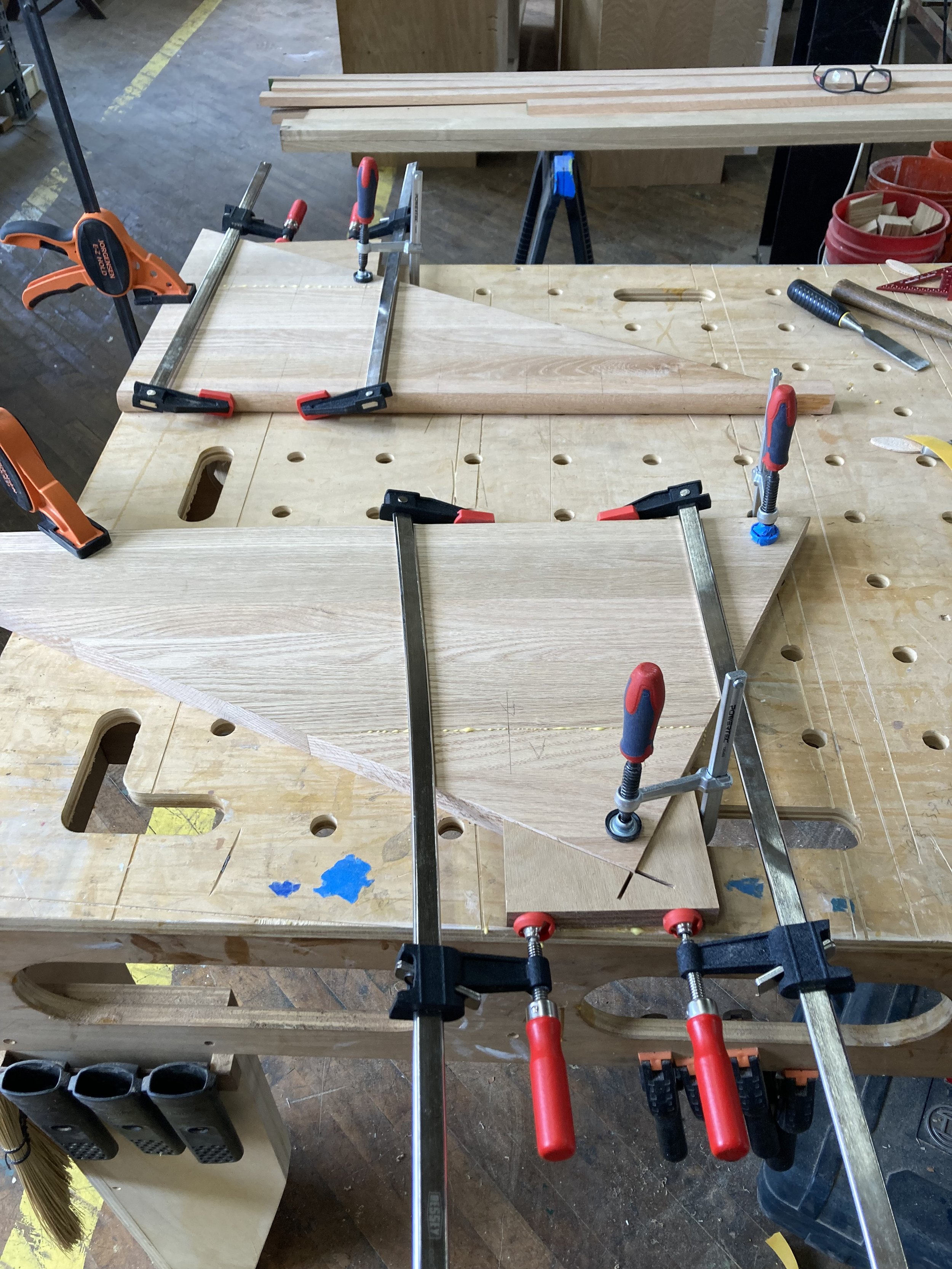 Workshop with wooden pieces clamped on a workbench