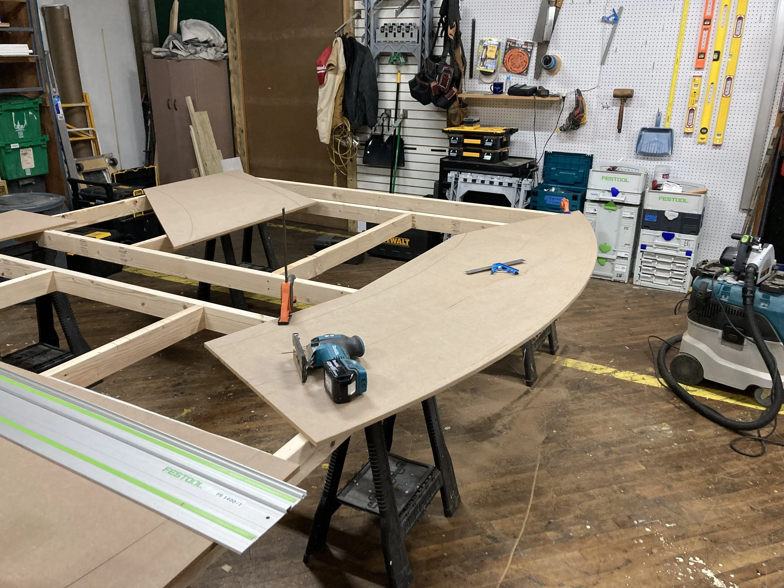 Woodworking workshop with tools, saws, and wooden frame structure in progress
