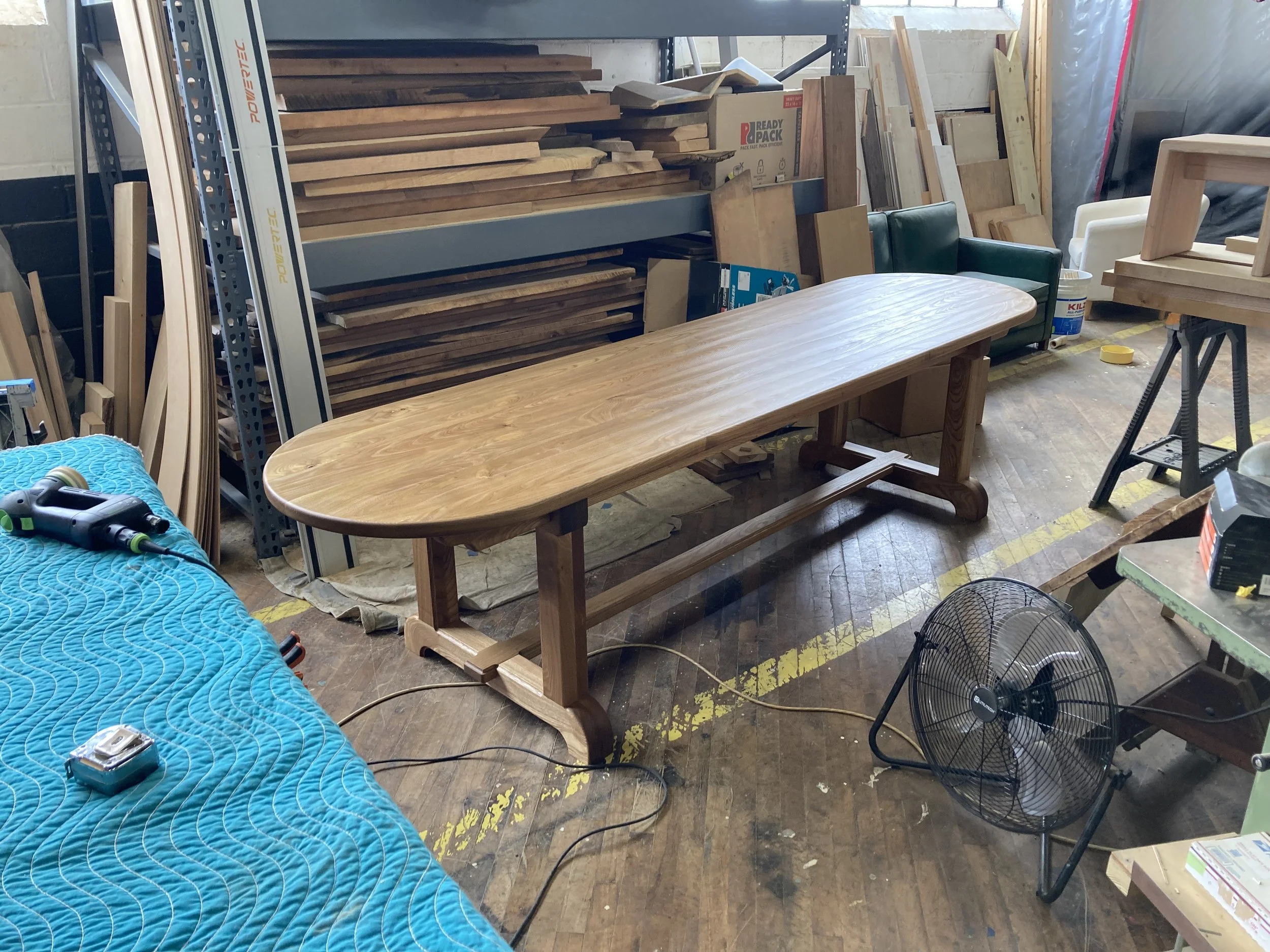 Woodworking shop with a wooden table and various tools and materials.