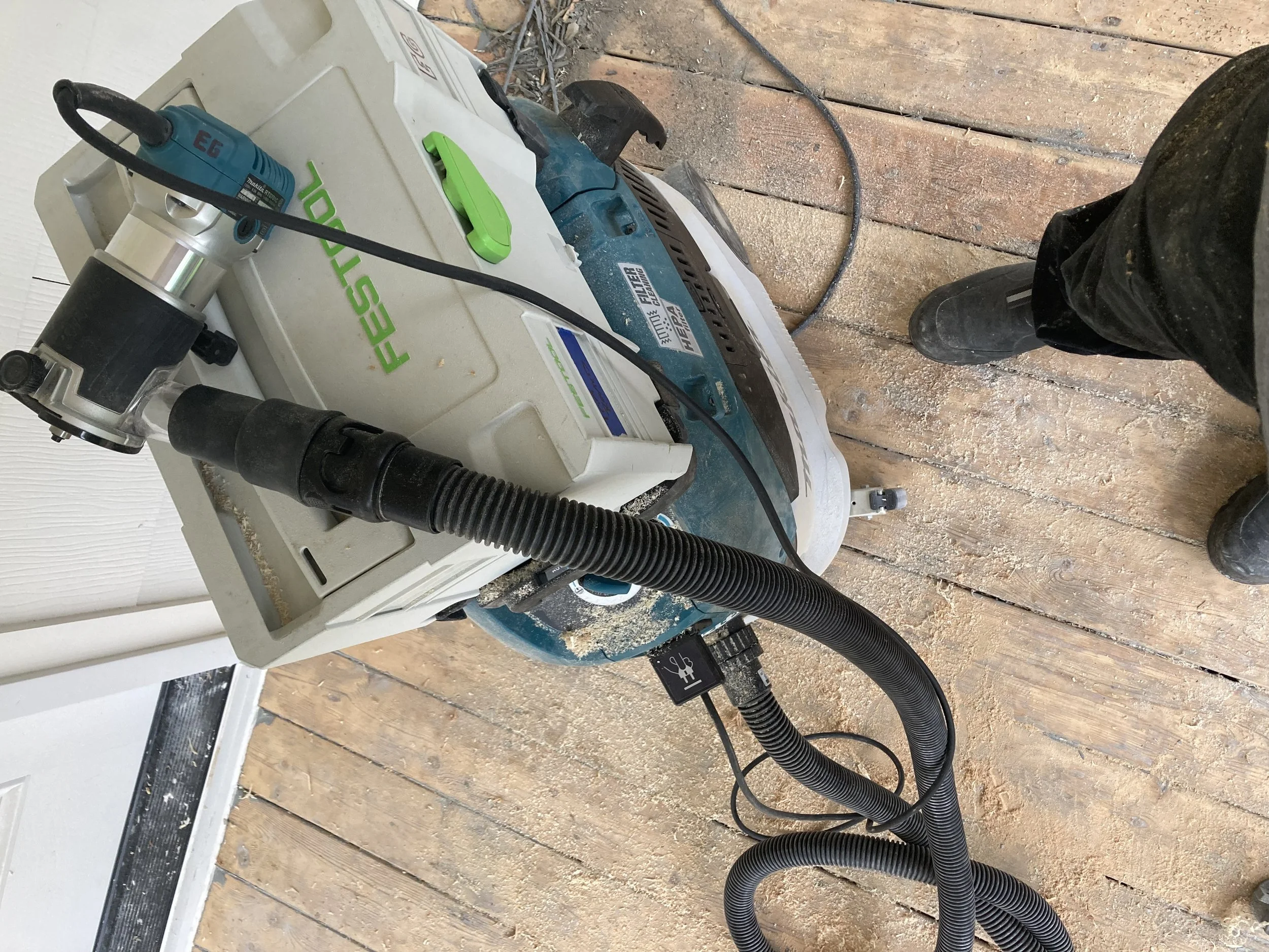 Sander and vacuum on wooden floor during renovation project