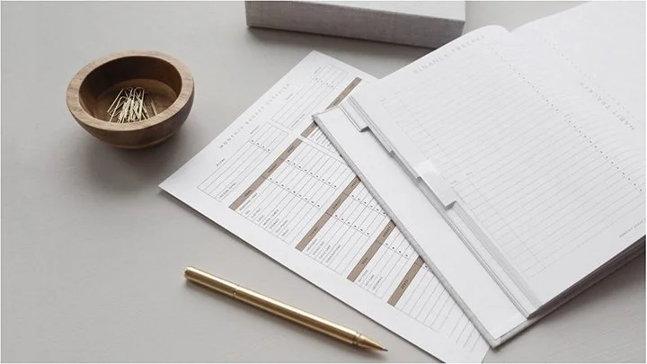 Image of a flat desktop with paperwork, pen, and paperclips