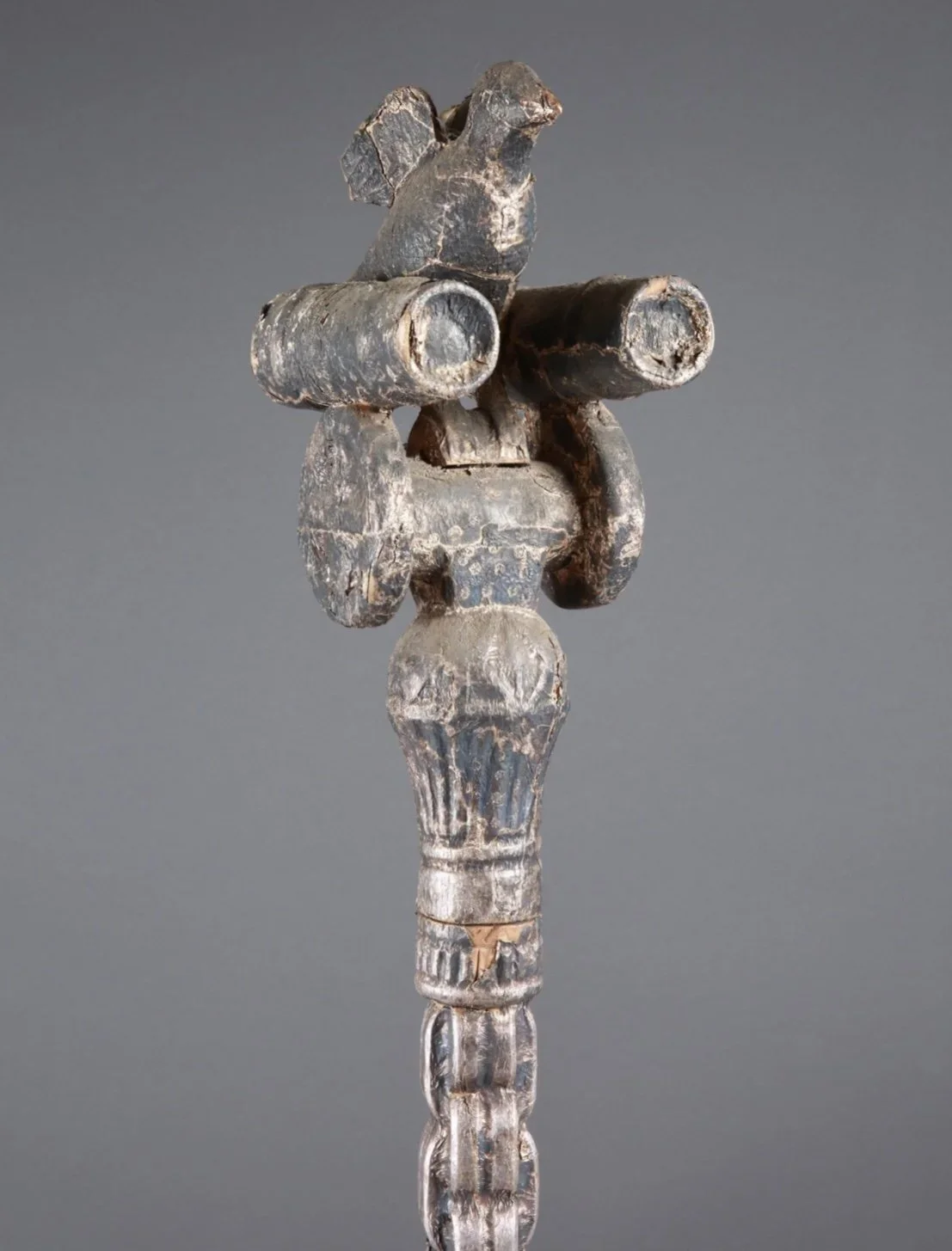 The image is the “bird that flies with cannons.” An exquisitely carved Asante “Okyeame poma” (linguist/counselor’s staff). Wood, hammered silver foil. Ghana. 62.5 inches H. Magnificent gold-covered staffs (or in this case silver covered) are carried