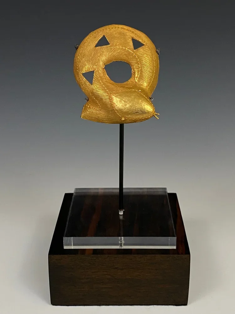 Lagoons people, cast gold alloy pendant of a coiled snake in fine wax thread technique. 3.9” L x 3” W. In Akan and Baule proverbs the coiled snake often are symbols of femininity and fertility. Ex Zemanek-Münster ex Roland Hartman ex René David ex Ro