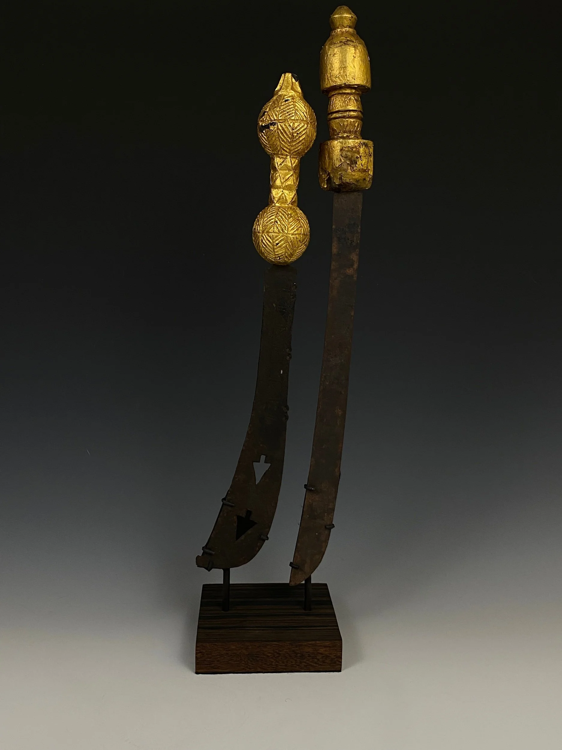 Two small Asante swords “afena”. Wood, steel, gold foil. Ghana. The left sword is a dance sword. “The accessories of an important chief also include a small sword held in the right hand and a horsetail fly whisk in the left. Although not without symb