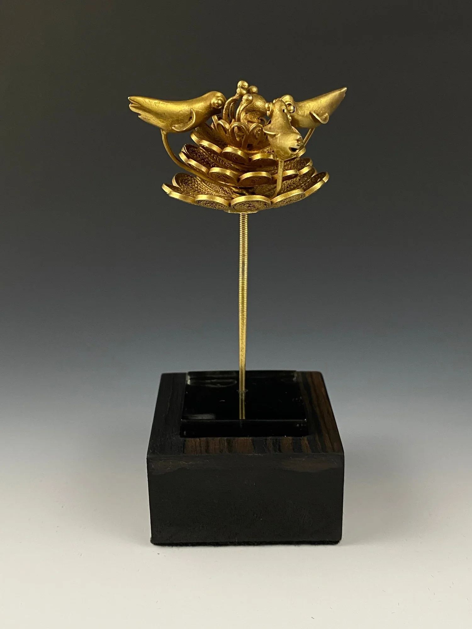 Hairpin, Asante, Ghana. Gold alloy. H 8.5 cm. The pin consists of three birds on a flower. The motifs shown always point to people, animals or objects that allegorically stand for praiseworthy qualities and sayings. Hairpins were generally believed t