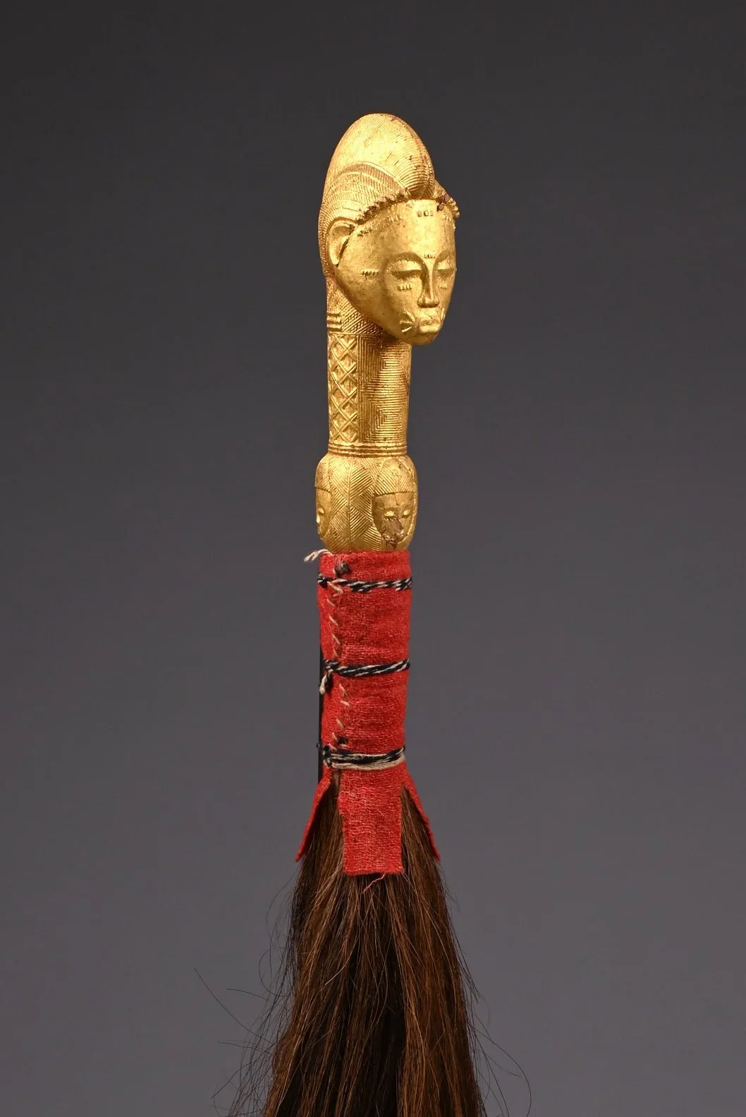 A Baule Fly Whisk (Nandwa Blawa) from Côte d'Ivoire, wood, gold foil, fabric, horse-tail. This fly whisk represents an ancestor to honor the spirits, an ever-present theme in Baule art objects. Covered with gold foil, fly whisks like this example was