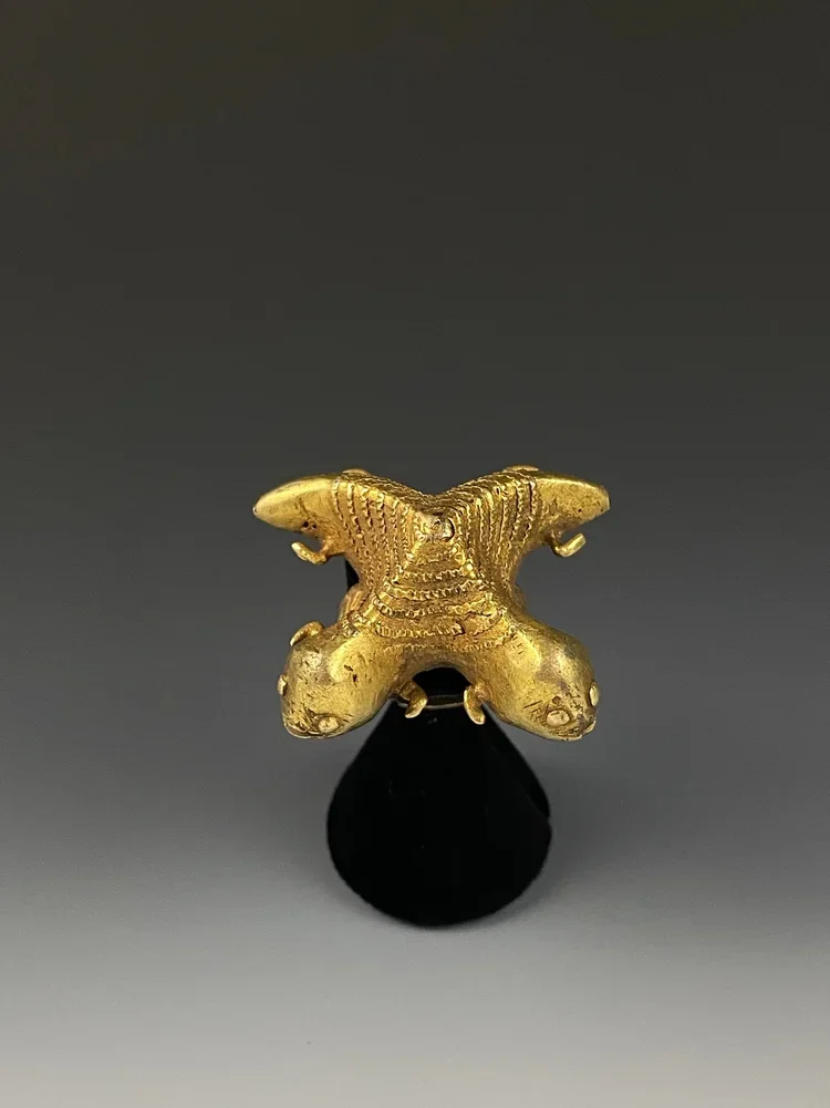 Akan Chief's ring "mpetea" of two crocodiles - Ghana. gold/silver alloy, 1.8 inch x 1.8 inch; D: 0.8 inch. The image displayed is of two crocodiles which share the same stomach. The proverb behind this image is “they share the same stomach, yet they