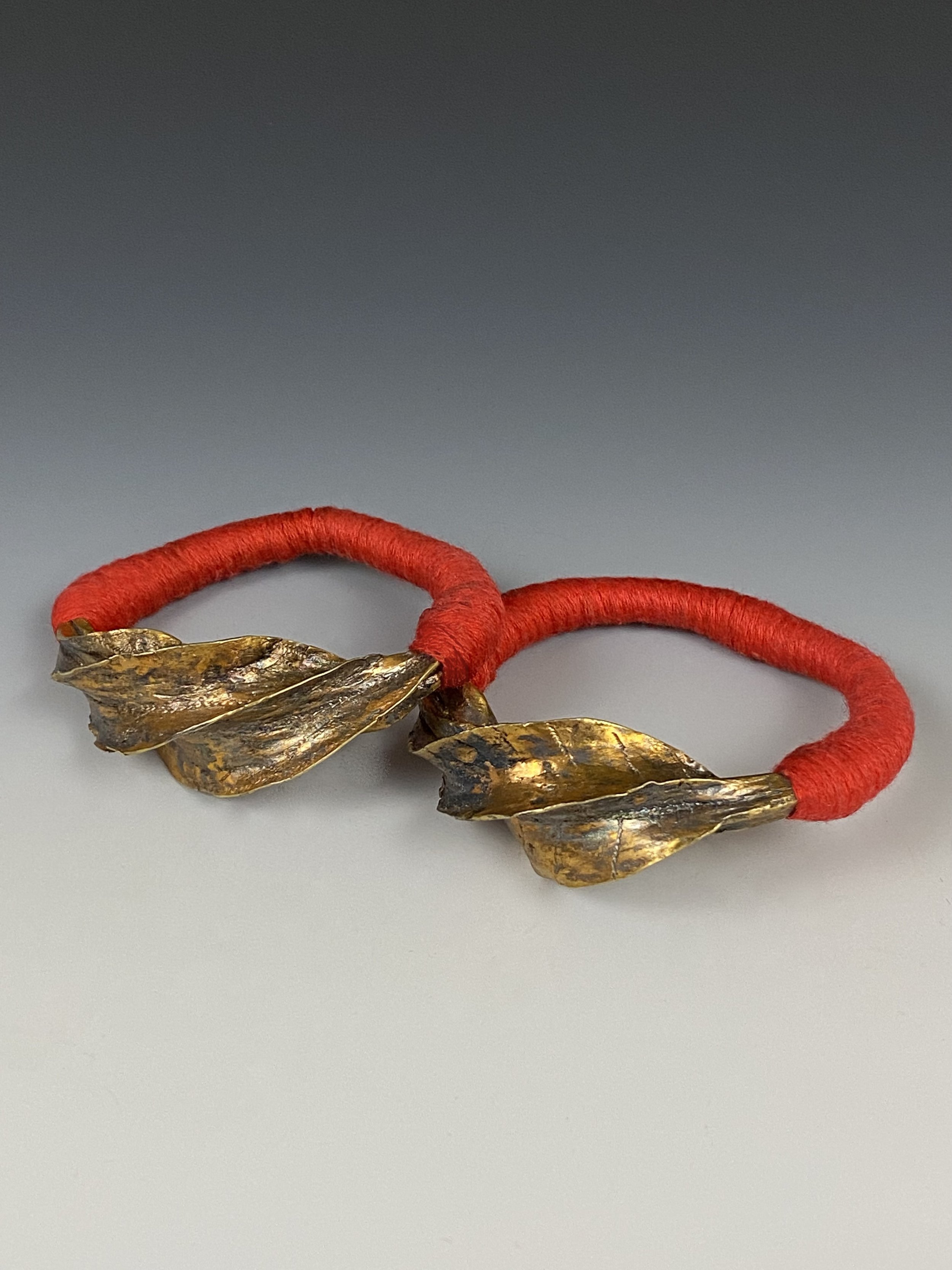 Peul earrings, "kwoteneye kange", Mali. Gilded hammered silver, fineness: 900, cotton. Ø 5 cm. Peul earrings are given as a wedding gift from the groom or received through inheritance on the mother's side, owned by woman as a symbol of wealth and sta