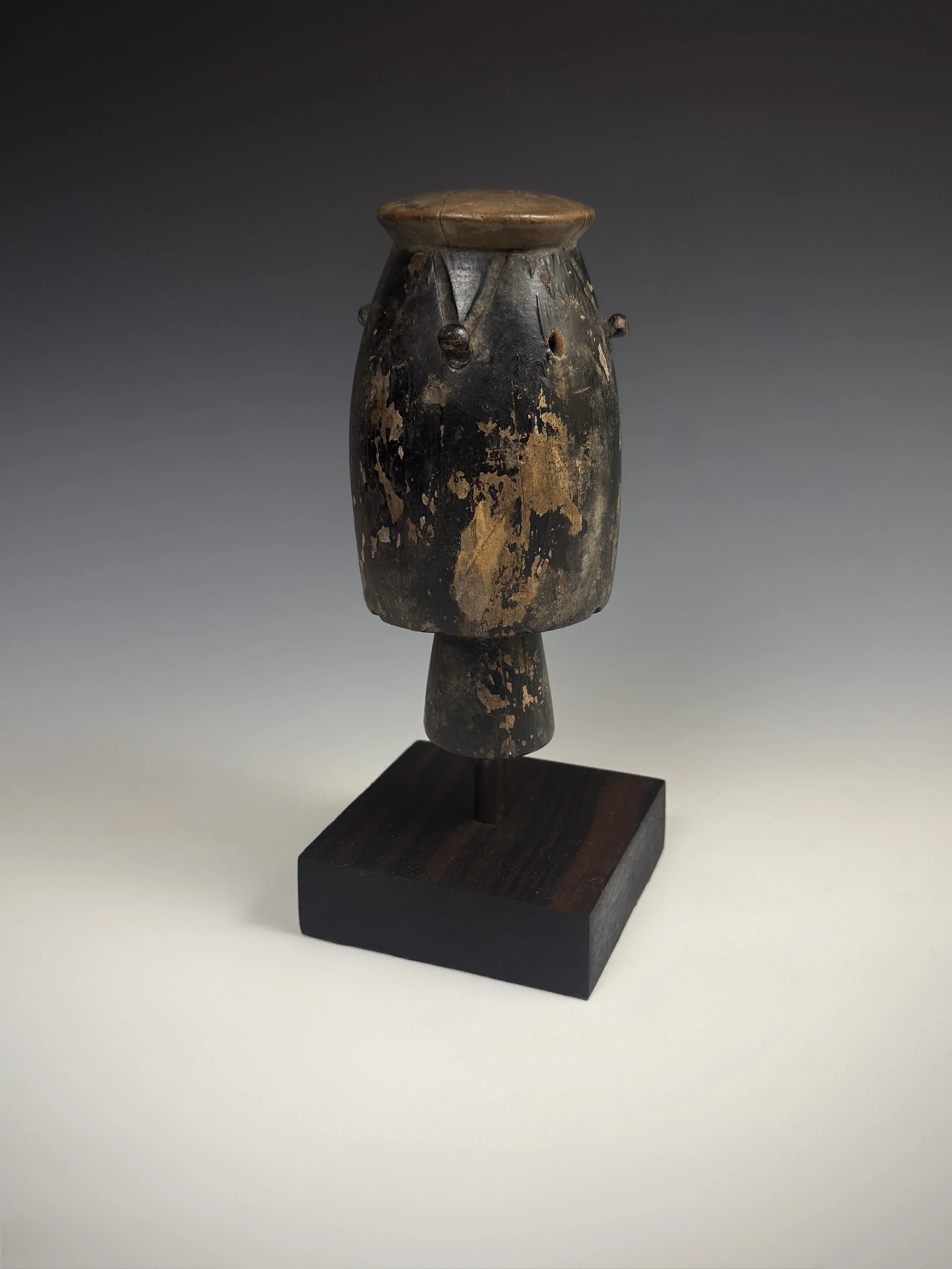 An Asante atumpan or apentema drum miniature (prestige item)  Ghana. Carved wood. H 14.5cm (5.7 inches).  The Atumpan is a talking drum sounded with two L-shaped sticks and played in pairs or with other instruments to accompany the adowa dance ensemb