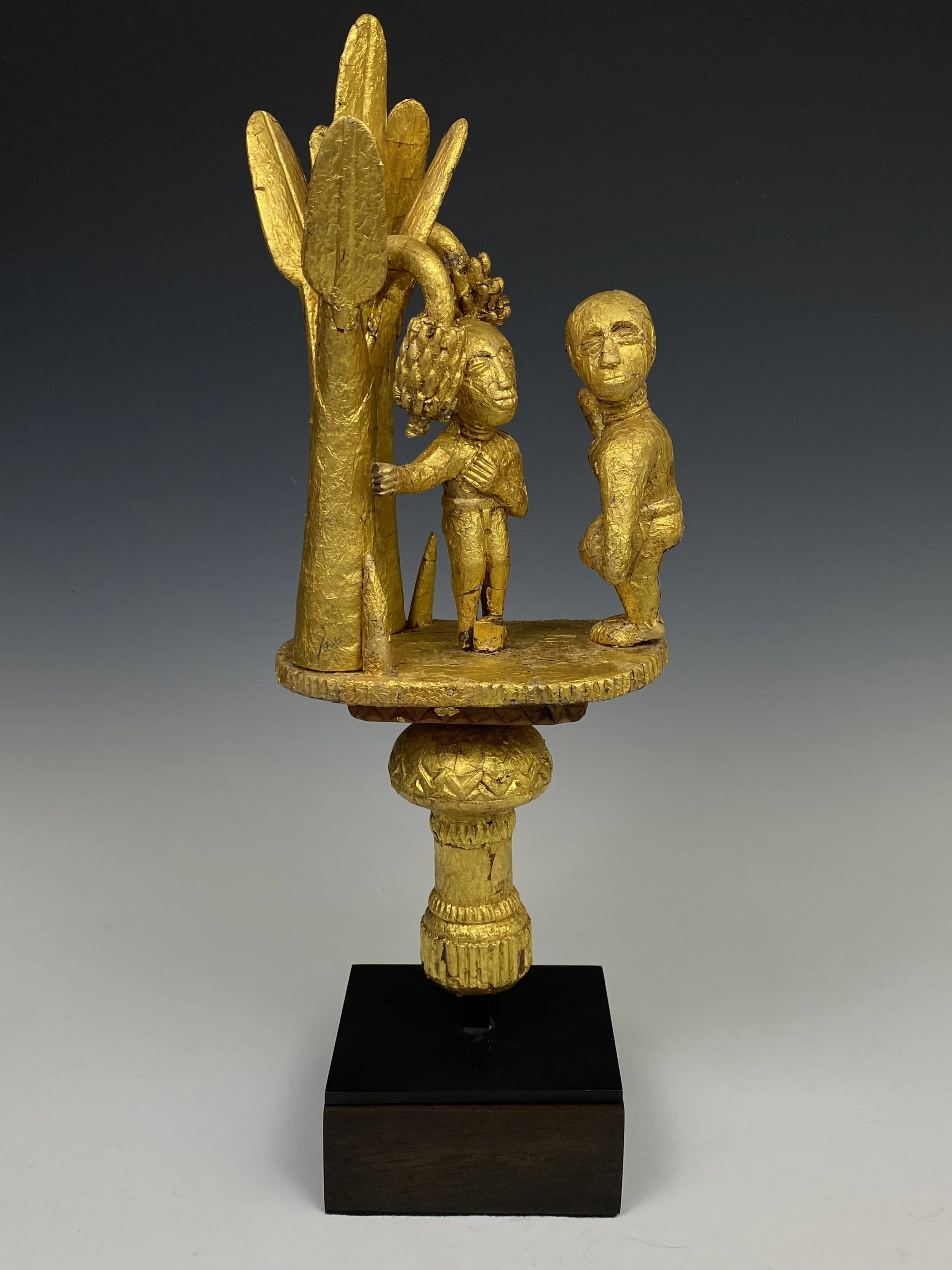 Asante linguist staff finial (ɔkyeame poma). Ghana, early 20th century. Carved wood, hammered gold foil. 15.5 h × 6.5 w × 6 d in (39 × 17 × 15 cm). A number of ɔkyeame poma represent messages of cooperative behavior within the state and between the c
