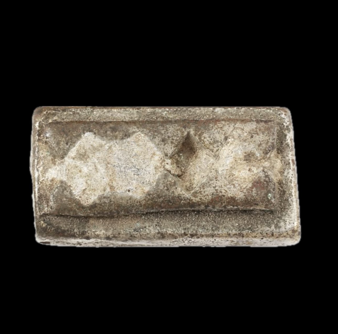 An Akan copper alloy gold weight with a geometric pattern consisting of two rows of consecutive triangle patterns forming diamonds on a 1' L rectangle.  Lead has been added for weight adjustment which has filled in the majority of the diamond shapes.