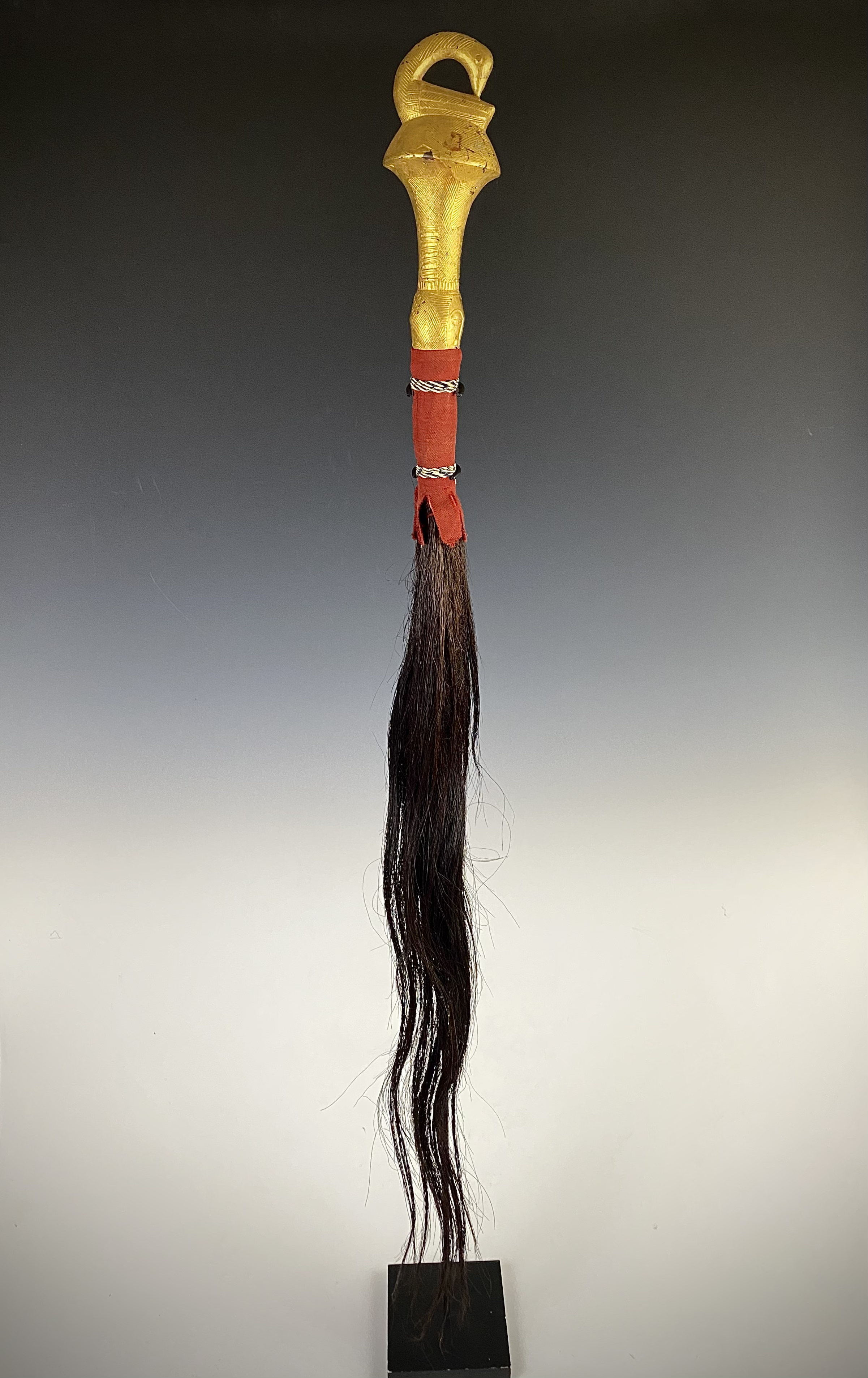Akan fly whisk, "nandwa blawa", Côte d'Ivoire/ Ghana, Wood, covered with gold foil, horse tail hair, textile. H 46 cm. (112 cm with tail). “One of the most familiar and influential images in all of Akan art is the bird with its head turned toward its