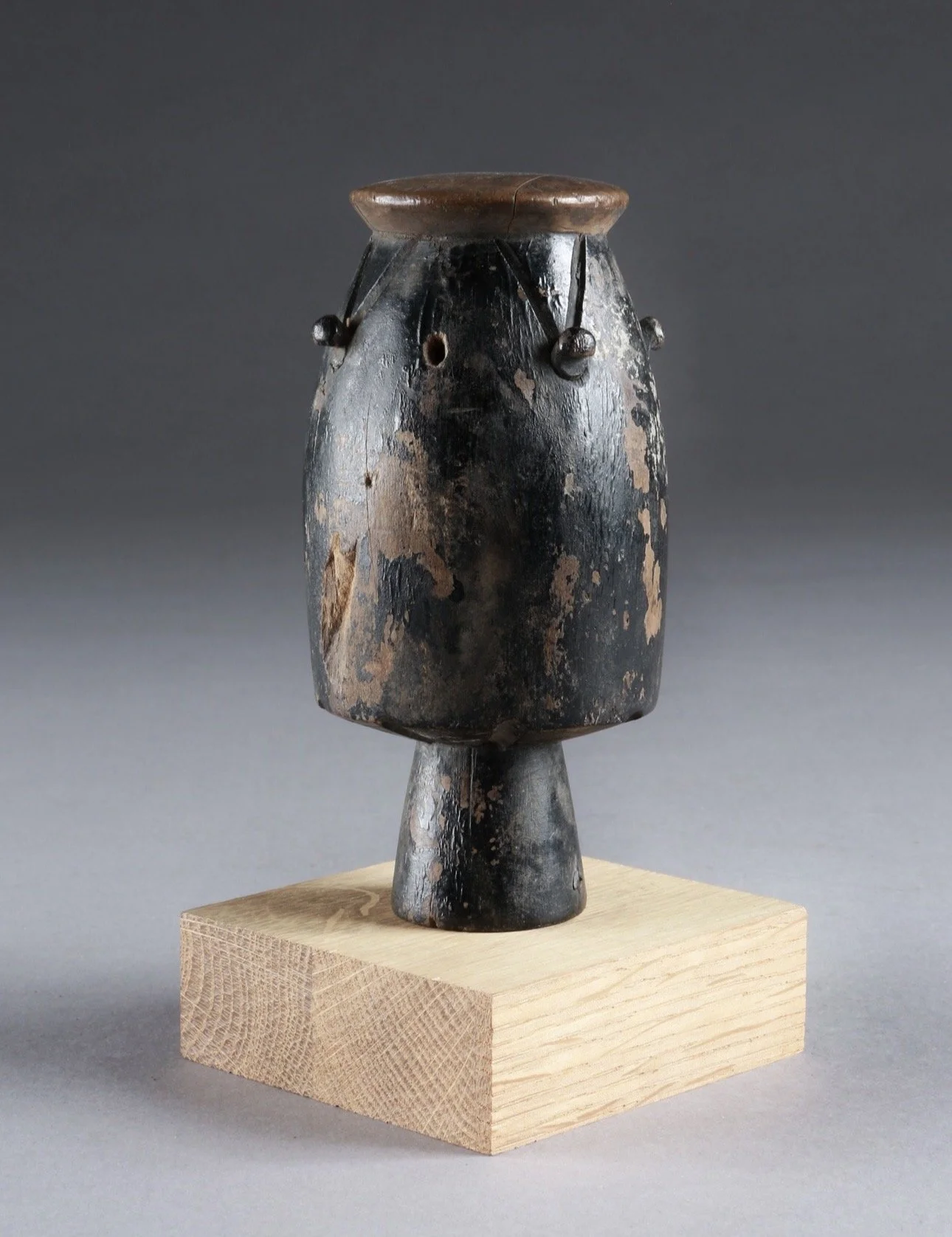 An Asante atumpan or apentema drum miniature (prestige item)  Ghana. Carved wood. H 14.5cm (5.7 inches).  The Atumpan is a talking drum sounded with two L-shaped sticks and played in pairs or with other instruments to accompany the adowa dance ensemb