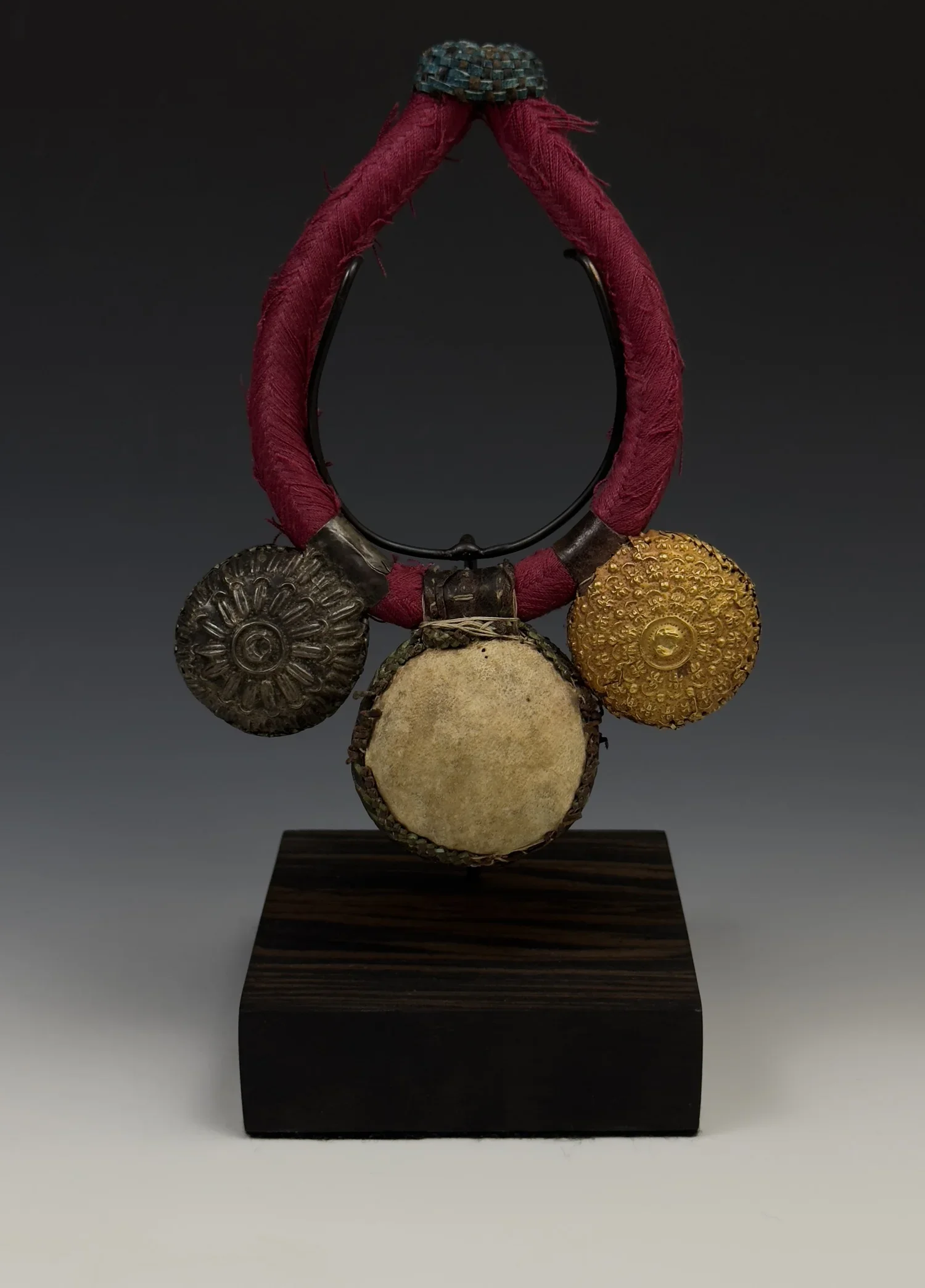 A rare and beautiful Asante “NSATIRE” elbow amulet with intricately decorated protection amulets covered with gold and silver sheet (repoussé). The gold and silver sheeting is attached by sewn gold and silver “thread”. Other materials include Leather