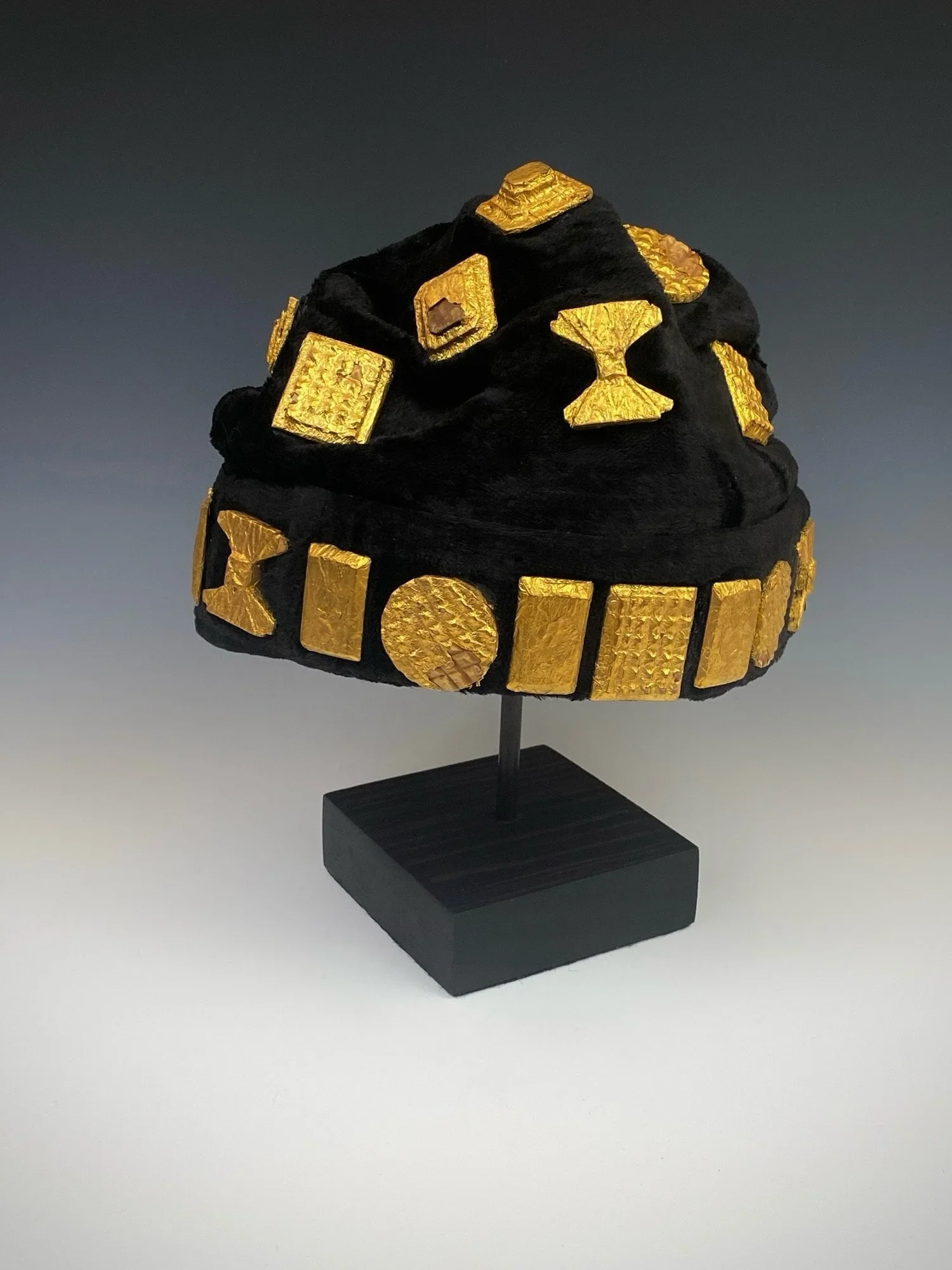 A chief’s crown (most likely coastal Akan states of Ghana). In the Akan states, the chief crowns and other headwear, aside from the abotire are in the category “kye”. Similar to the abotire the entire top is enclosed and is covered with amulets made 