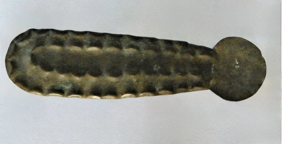 Asante copper alloy embossed gold dust spoon “Nsawa (saawa)” with a deep repoussé crocodile back pattern. Used for measuring out gold dust to the scales. 3" L.  Ghana. Ex Bruce Burt, Rincon Puerto Rico, previously New York, NY where he owned a galler
