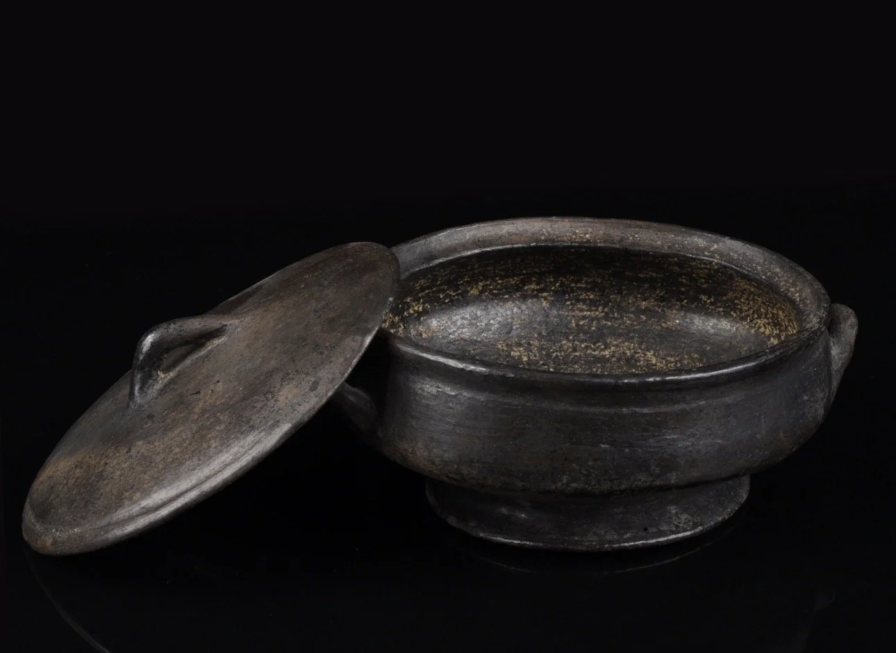 An Asante terracotta bowl with two side handles and a lid.  Ghana. H 9.5 cm. Ø 17 cm.
Provenance:  - Brigitte Menzel (1930-1998), Berlin.   - Erbengemeinschaft Menzel, Berlin.
                - 2013: Galerie Walu, Zürich.
                - Hammer Auk