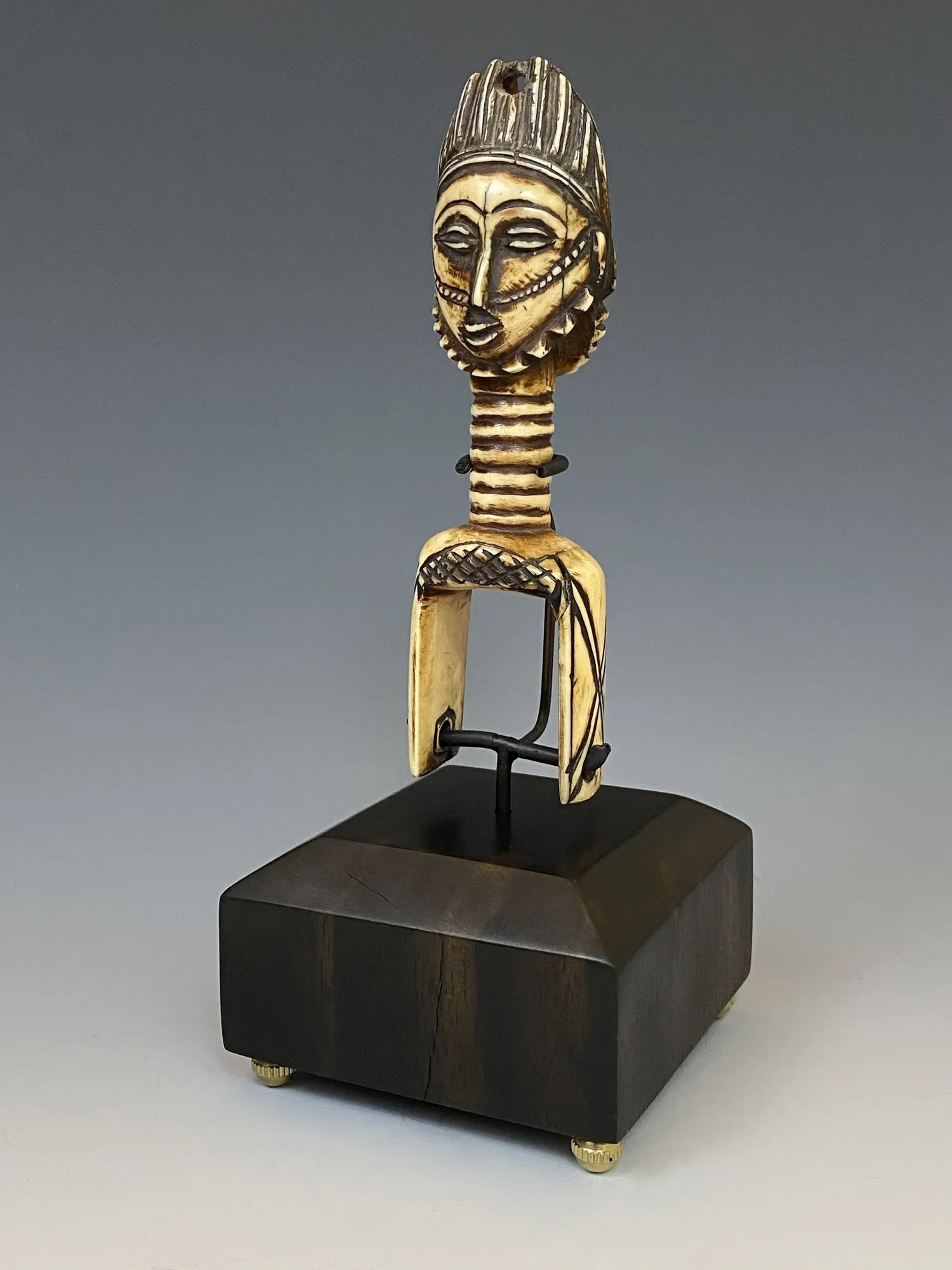 A very old and rare (because of the material) Baule double faced (Janus) heddle pulley from Côte d‘Ivoire, 15cm without base. It’s missing the inner wheel and spindle. Baule heddle pulleys are functional display objects used both as a tool on the loo
