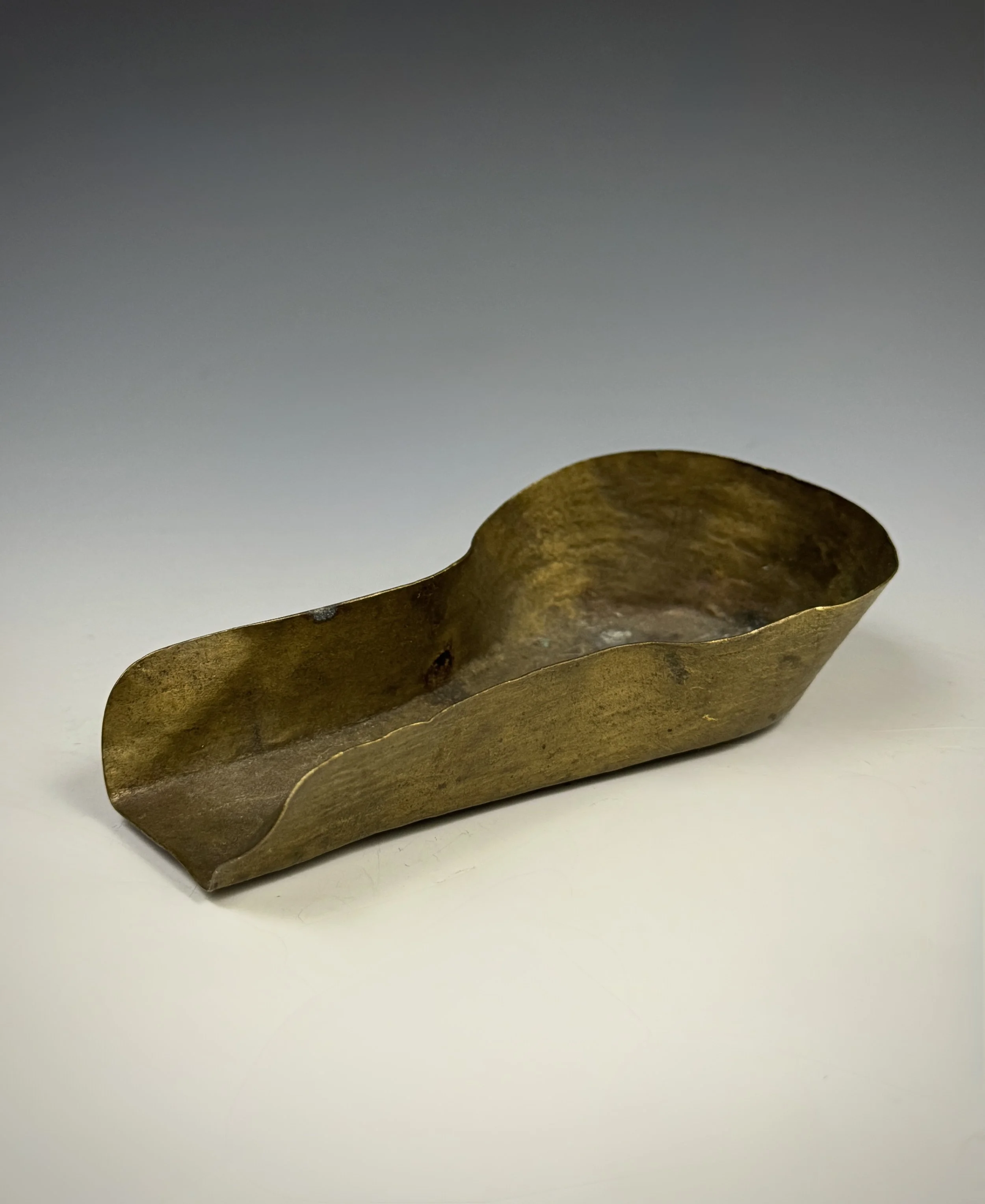 An Akan brass gold dust pan/scoop (Famfa), Ghana/Côte d'Ivoire. Brass scoops like this one were used as gold pans to separate the gold dust particles from the surrounding material. Ex Vérité collection, France. Pierre Vérité (1900-1993) began collect