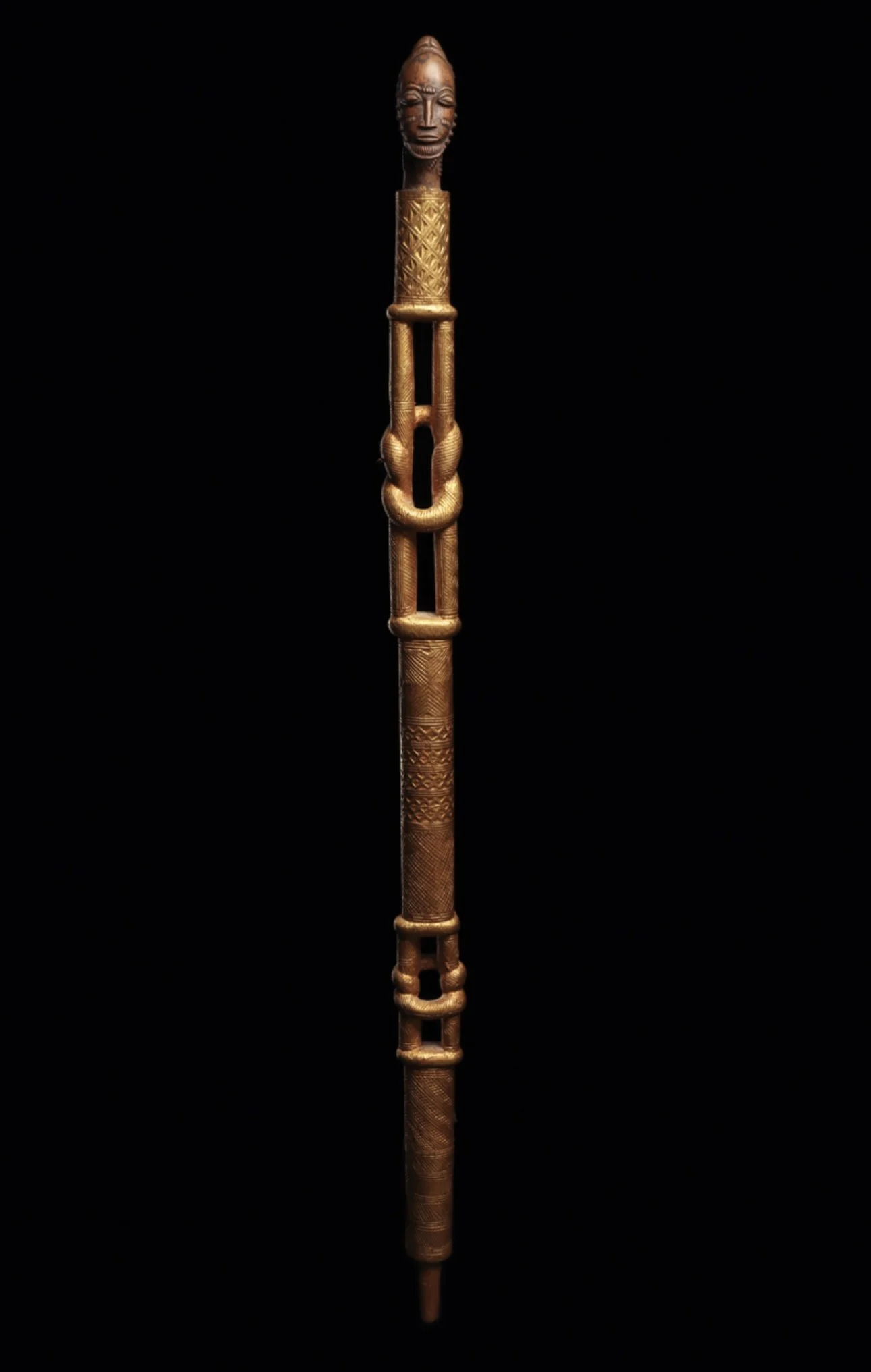 This is a beautifully carved Baule or Akan staff fragment with the bottom half section missing. Wood, covered with gold foil. 30” L (Côte d’Ivoire). It is most likely a chief’s staff or possibly a Baule variation of the Akan linguist staff. The staff