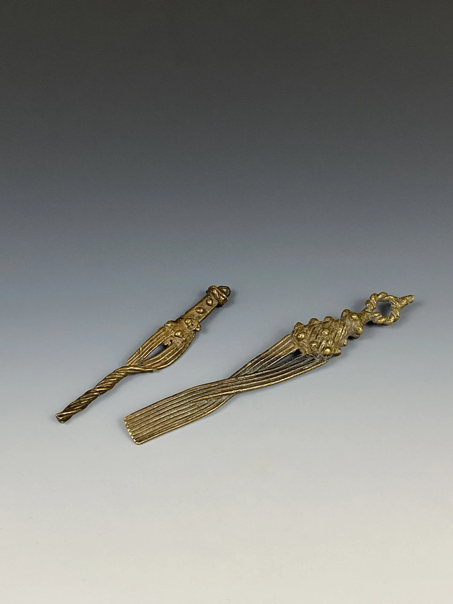 Two Asante 19th c. gold weight in the shape of a Elephant tail fly whisk (mena). Bronze.