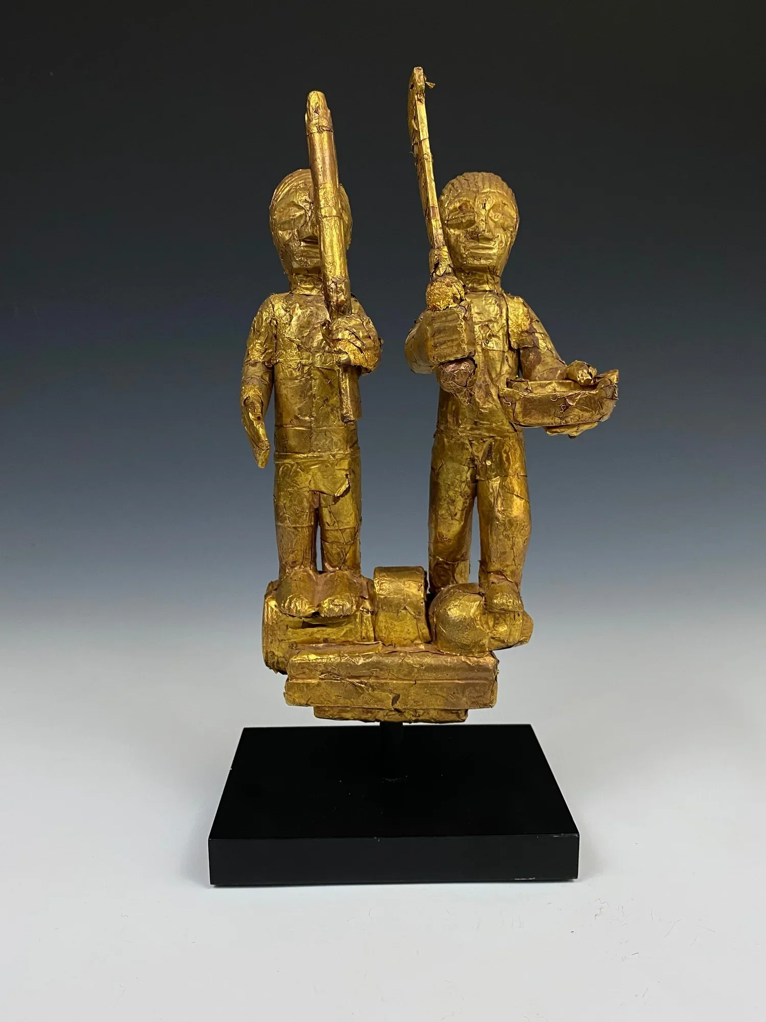 An Asante linguist staff finial (okyeame poma) portraying two Asante warriors: one with a gun, standing on a powder keg and the other with an akrafena sword standing on the severed head of a fallen enemy. This could commemorate a localized battle or