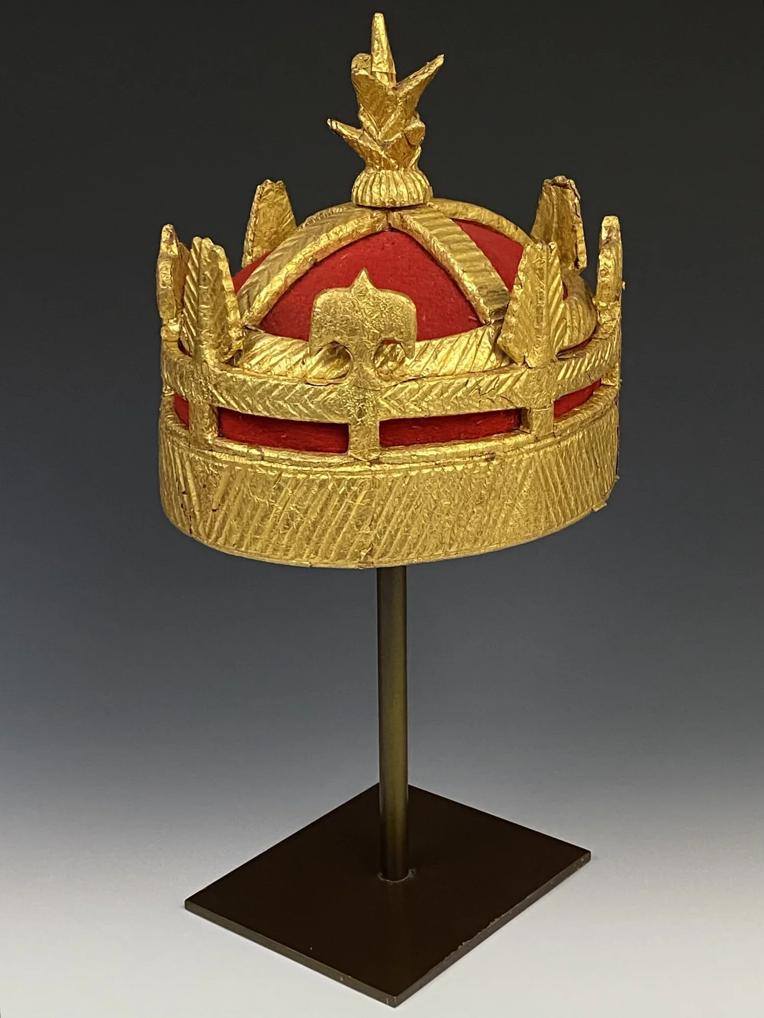 Asante chief’s regalia “crown”. The chief’s “crown” is strongly influenced by European heraldic symbolism with a combination of Akan symbolism. The finial can be interpreted as a palm tree which is seen as a symbol of strength since it is among the s