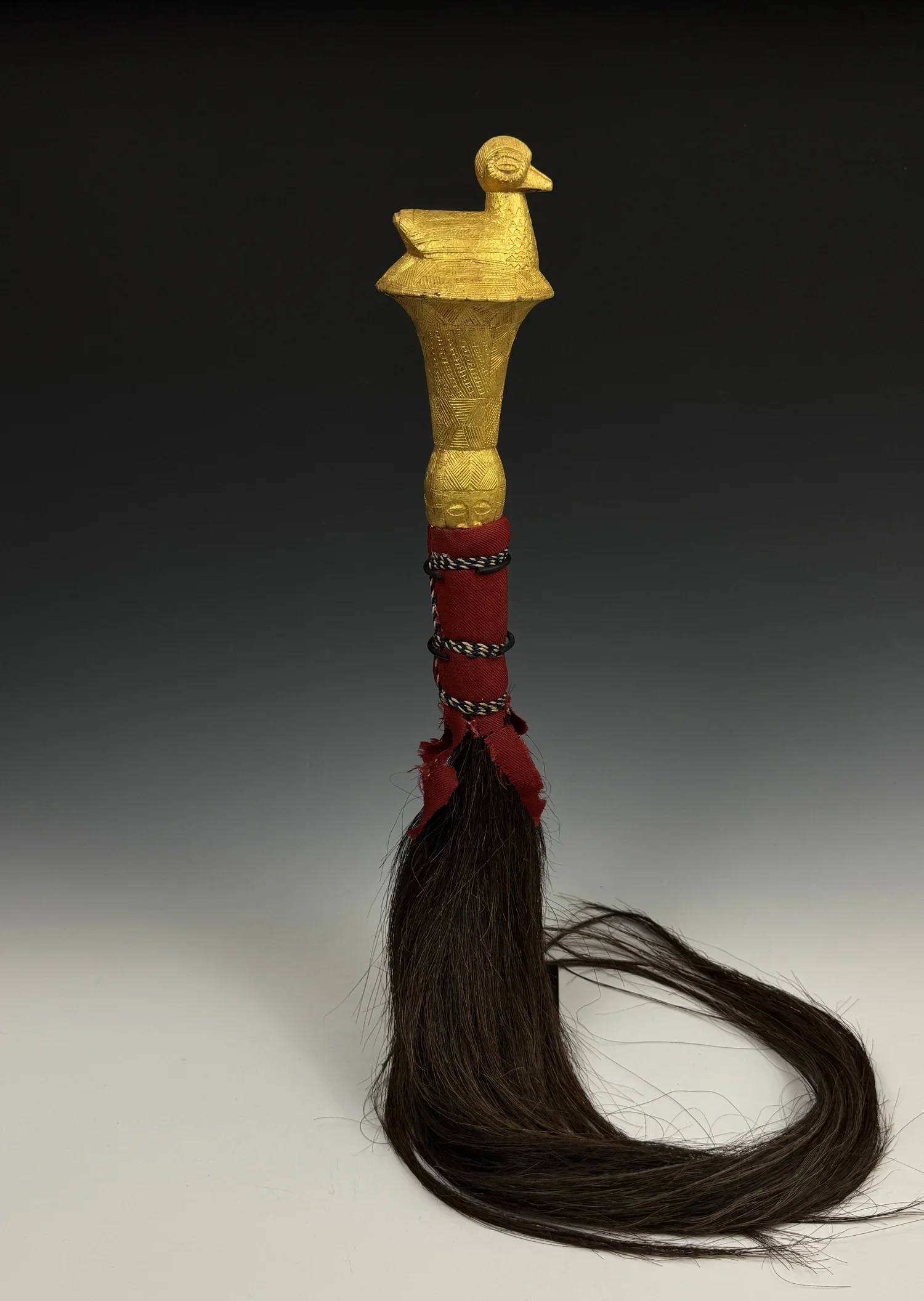 Baule fly whisk with a finial of a bird- this time a water fowl. 33” L. Wood, covered with gold foil, horse hair, and textile. Côte d’Ivoire. EX Constance McCormick Fearing estate, Montecito, California.