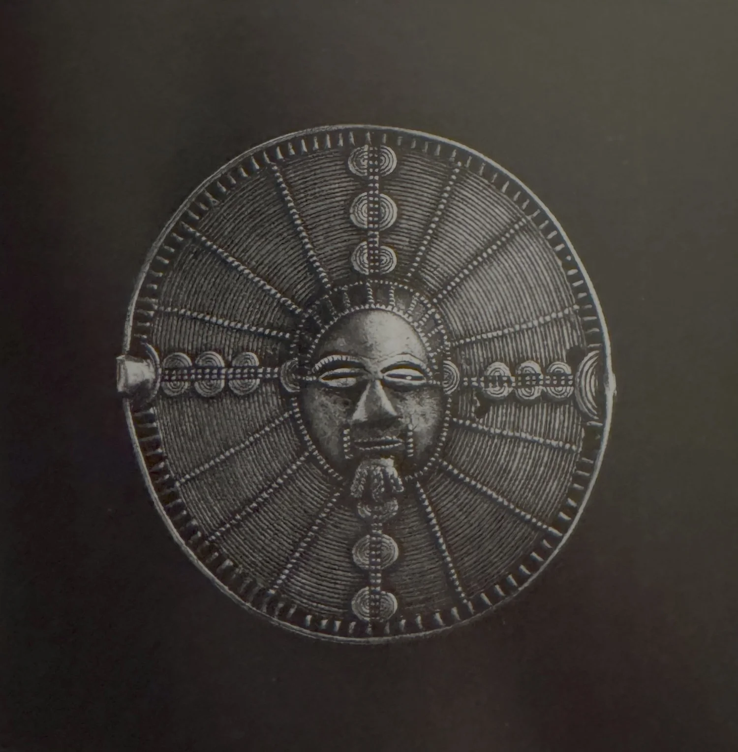 Two beautiful cast silver Akan pendants. Côte d’Ivoire. Radial sun motif— with a central ancestral mask. They are variants to the Akrafokonmu, or “soul washer’s” discs- often worn by individuals closest to the chief that are said to hold a part of th