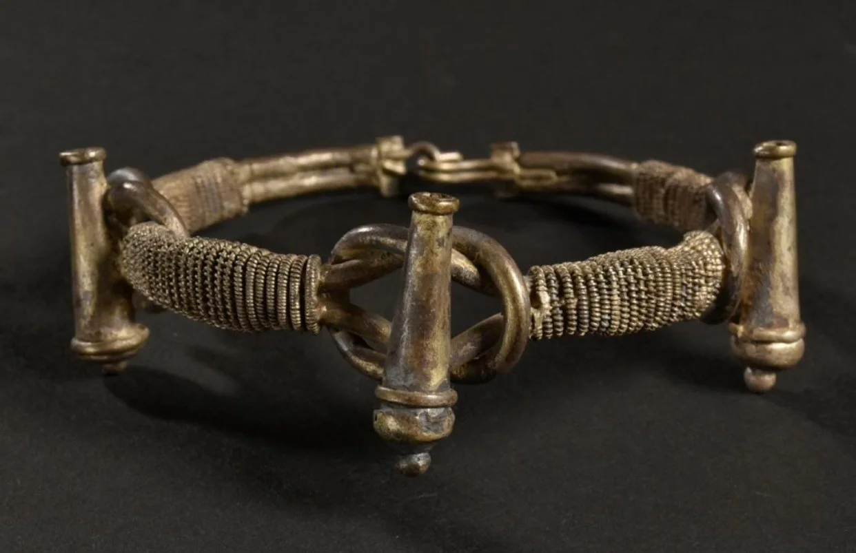 Asante silver bracelet with 3 cannons representing strength and readiness on top of 3 wisdom knots "NYANSAPO"- the symbol of wisdom, ingenuity, intelligence and patience. "An especially revered symbol of the Akan, this symbol conveys the idea that "a