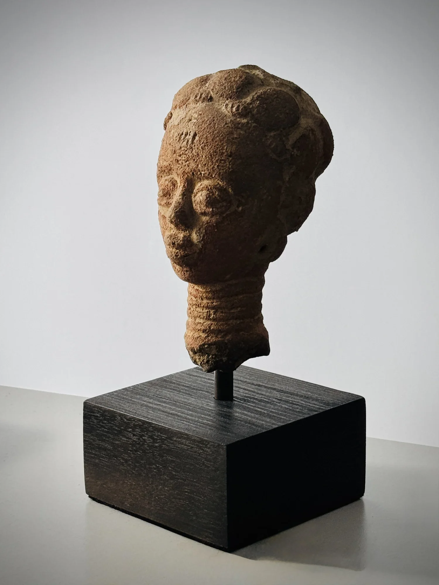 A small Akan- Twi memorial head. Ghana. H 6" x 3" W. Elaborately modeled hairstyle and scarification.