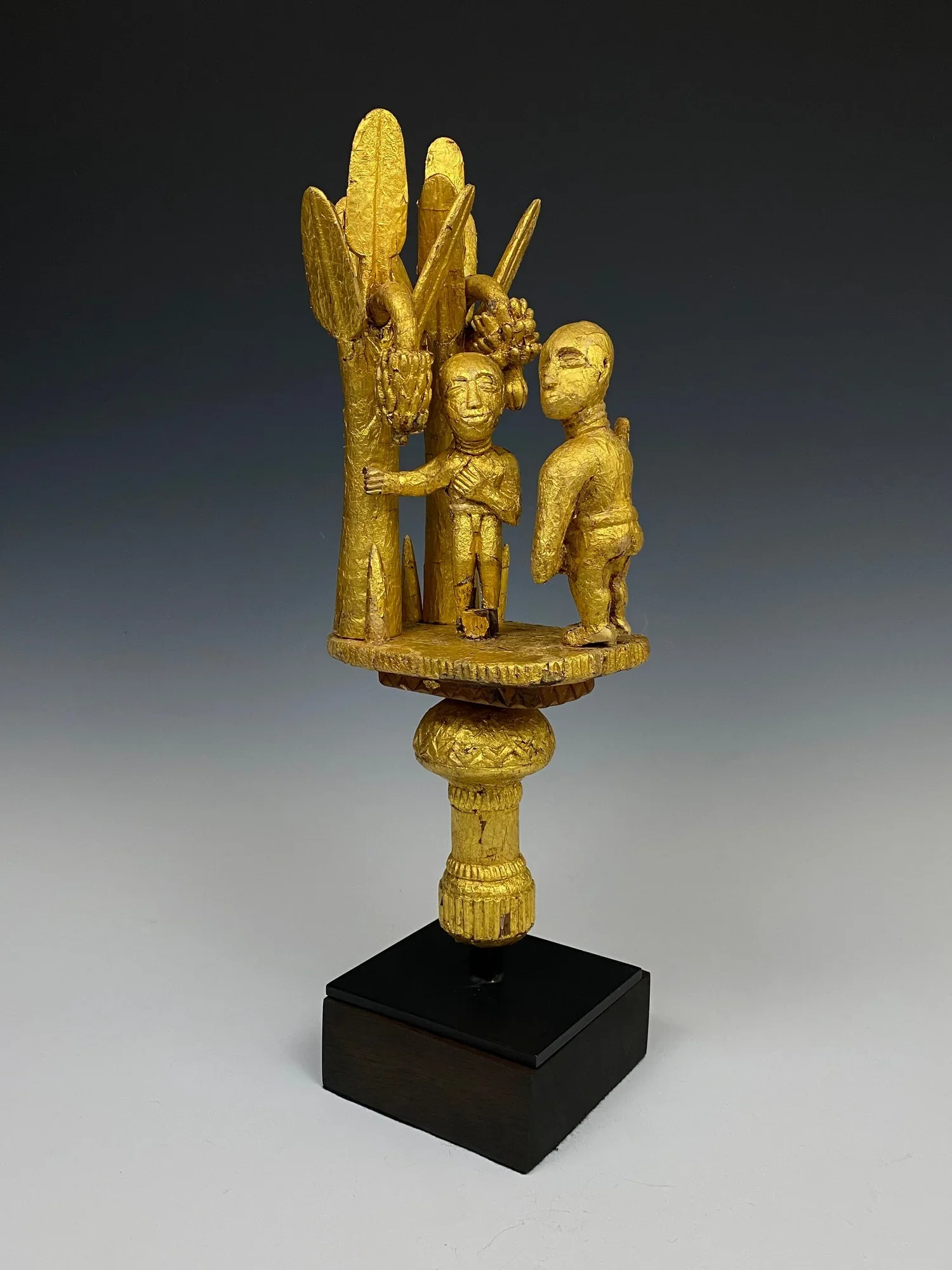 Asante linguist staff finial (ɔkyeame poma). Ghana, early 20th century. Carved wood, hammered gold foil. 15.5 h × 6.5 w × 6 d in (39 × 17 × 15 cm). A number of ɔkyeame poma represent messages of cooperative behavior within the state and between the c