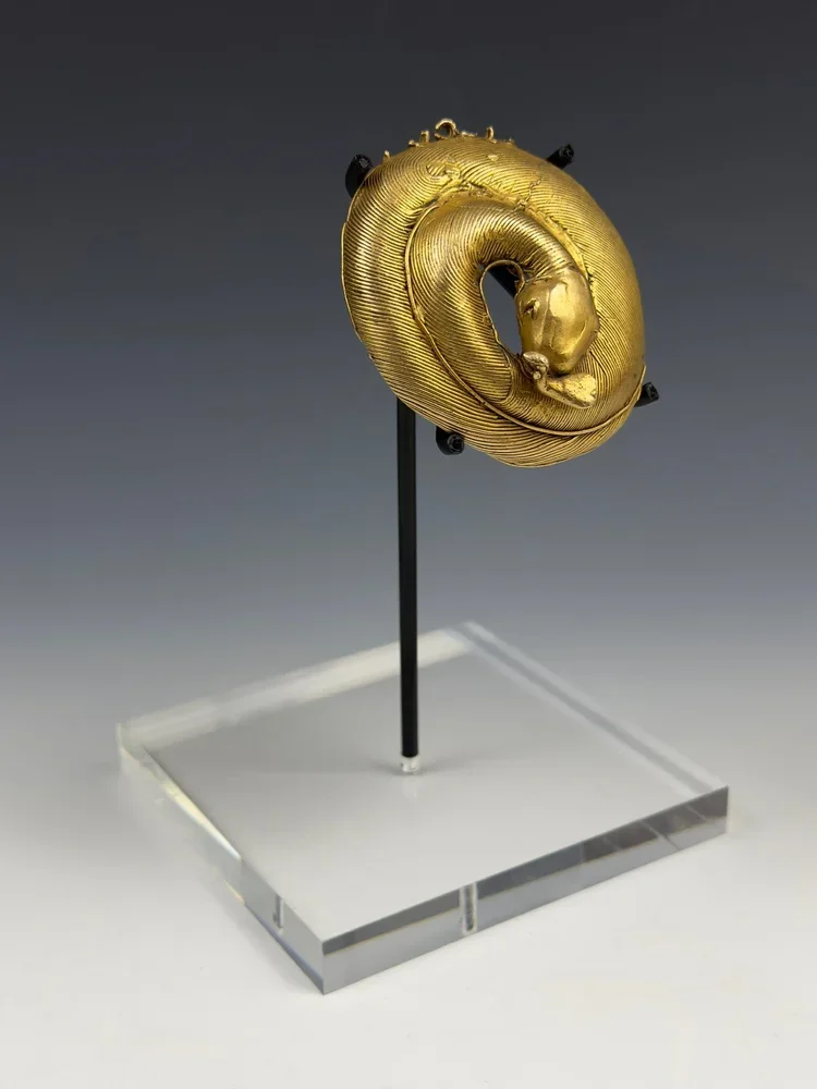Akan cast gold (12K, 30g) pendant representing a coiled snake with a bird in its mouth. D: 2.4 inch - 2.6 inch. In Akan art, the snake is often seen devouring a variety of animal types. Sometimes it is a bird as in this example. Other examples seen i