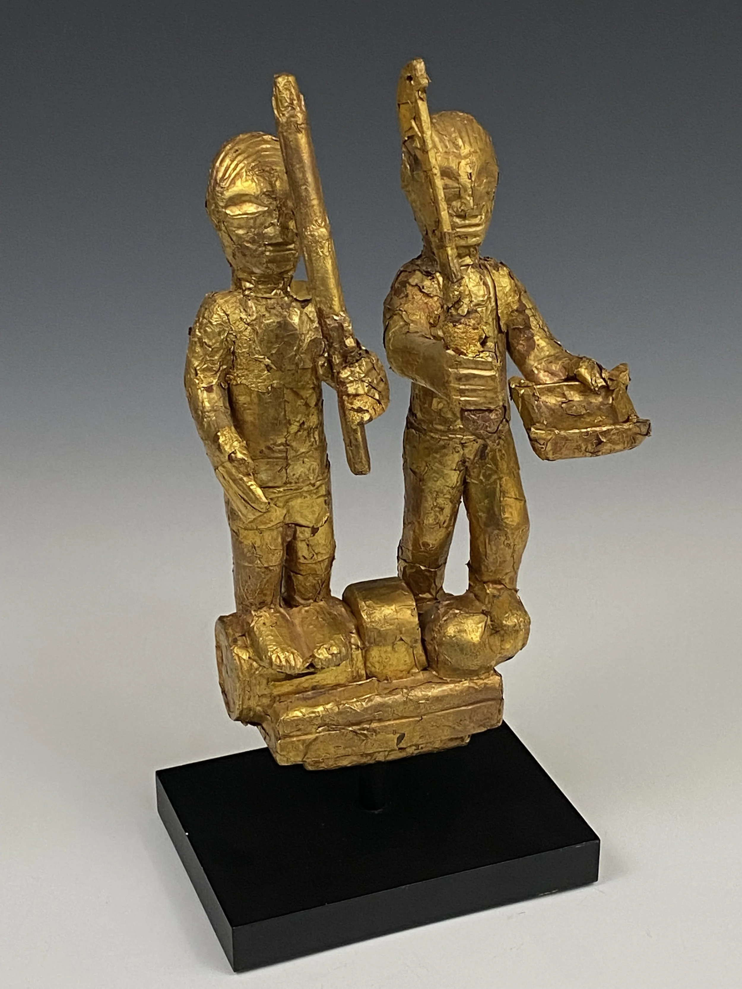 An Asante linguist staff finial (okyeame poma) portraying two Asante warriors: one with a gun, standing on a powder keg and the other with an akrafena sword standing on the severed head of a fallen enemy. This could commemorate a localized battle or