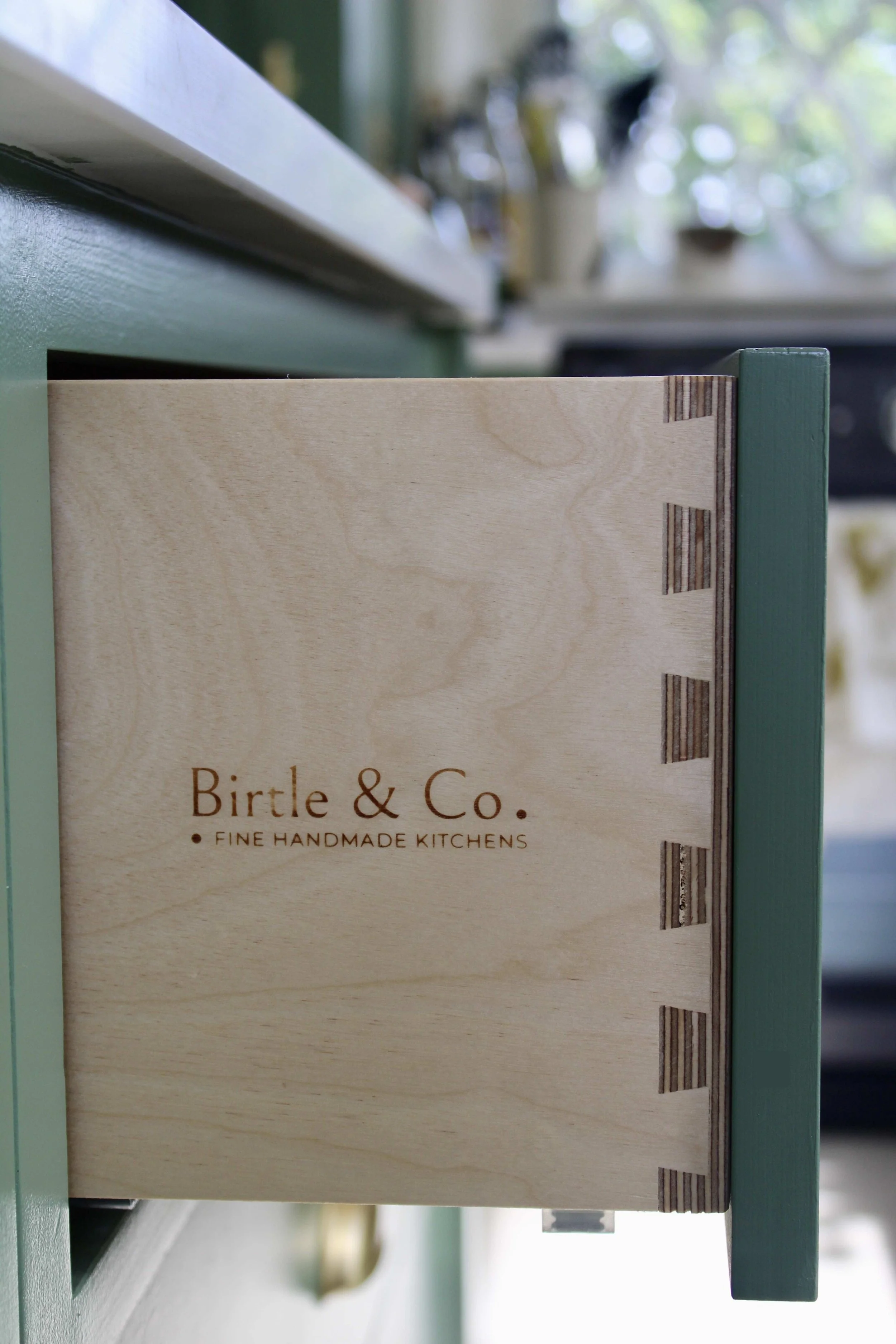A partially visible glass jar on a wooden shelf mounted on an orange wall.