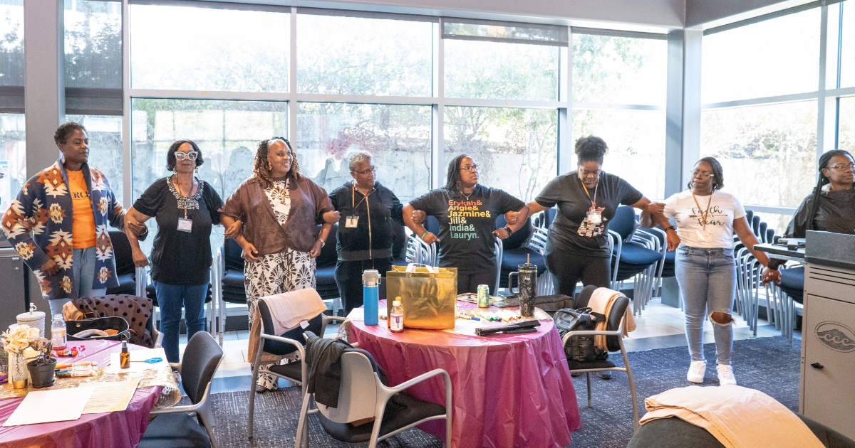 A group of Black women link arms during the 2026 Black Women’s Sanctuary Conference.