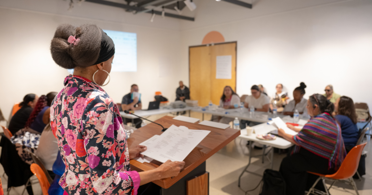 A CELI participant presents from the podium during the Spring 2026 mock board meeting exercise.