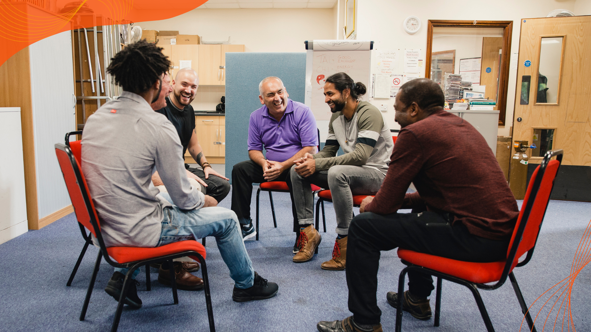 Men sit in a circle during a group coaching or support session.