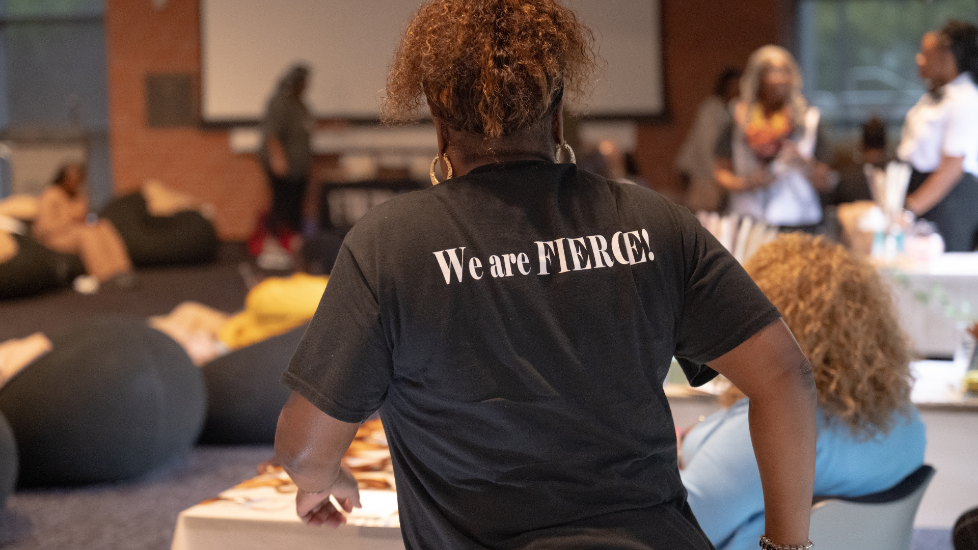 FIERCE Advocates team member wearing a “We are FIERCE” shirt during a community wellness gathering.