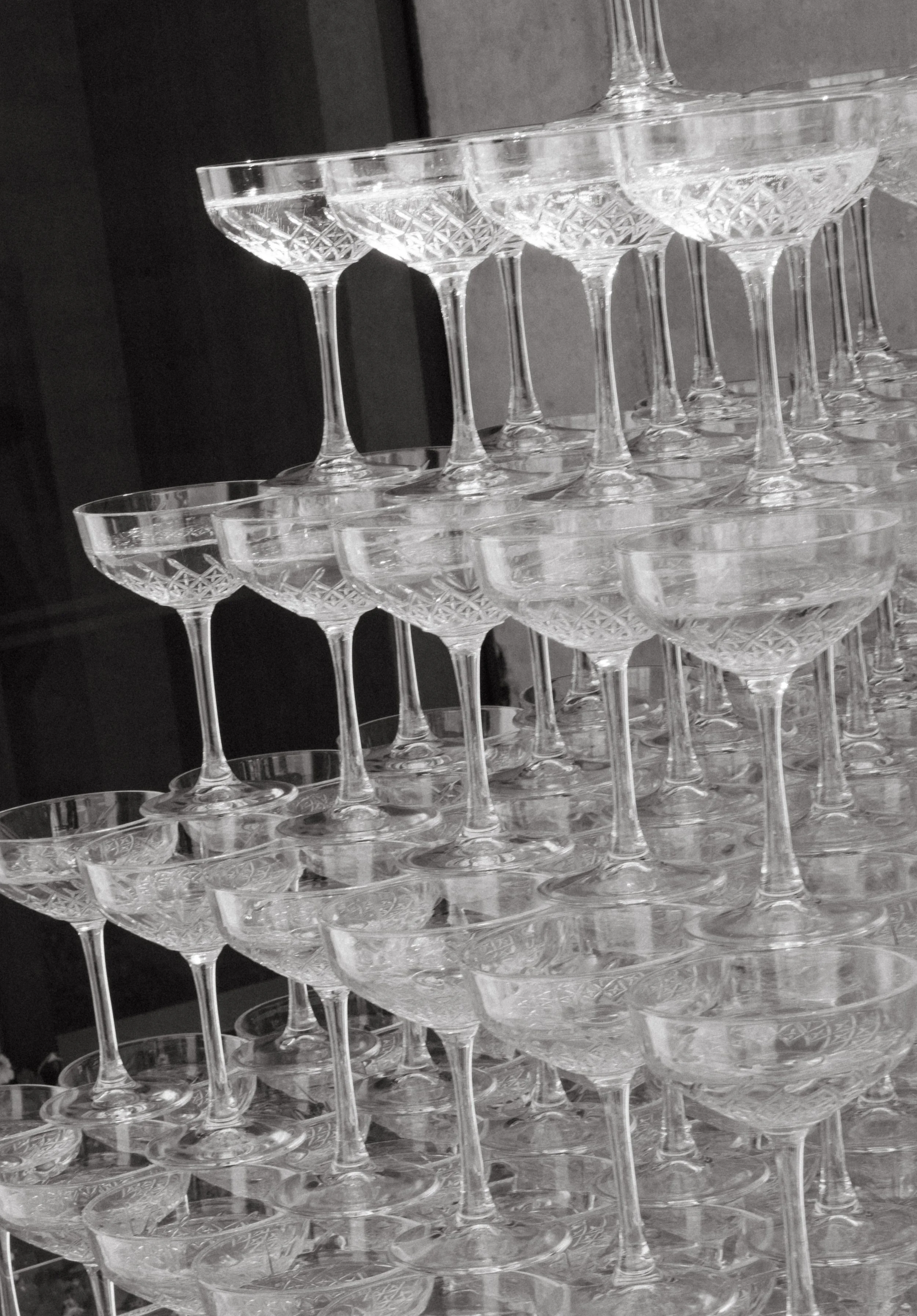 Stacked crystal cocktail glasses with intricate cut designs, arranged on a flat surface.