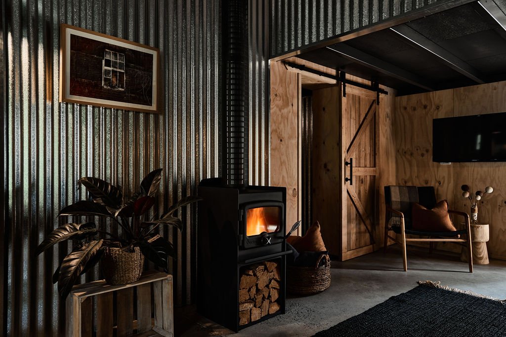 Cosy-living-area-with-wood-fireplace-and-comfortable-armchairs-at-Shepherds-Hill-Shearers-Quarters.jpg