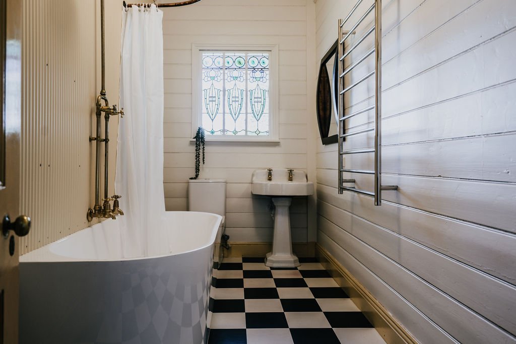Modern_bathroom_featuring_deep_soaking_bath_under_leadlight_window_at_Shepherds_Hill_Cottage.jpg