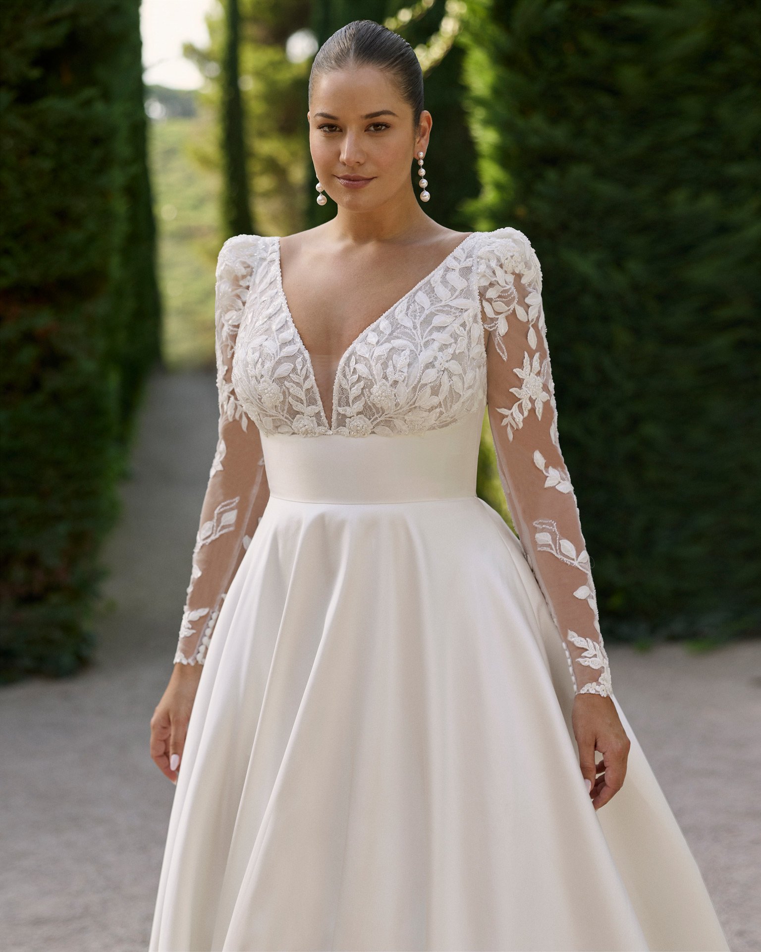 Corpete rendado do vestido de noiva Kim, com decote em V profundo, mangas compridas removíveis em renda e cintura definida em mikado.