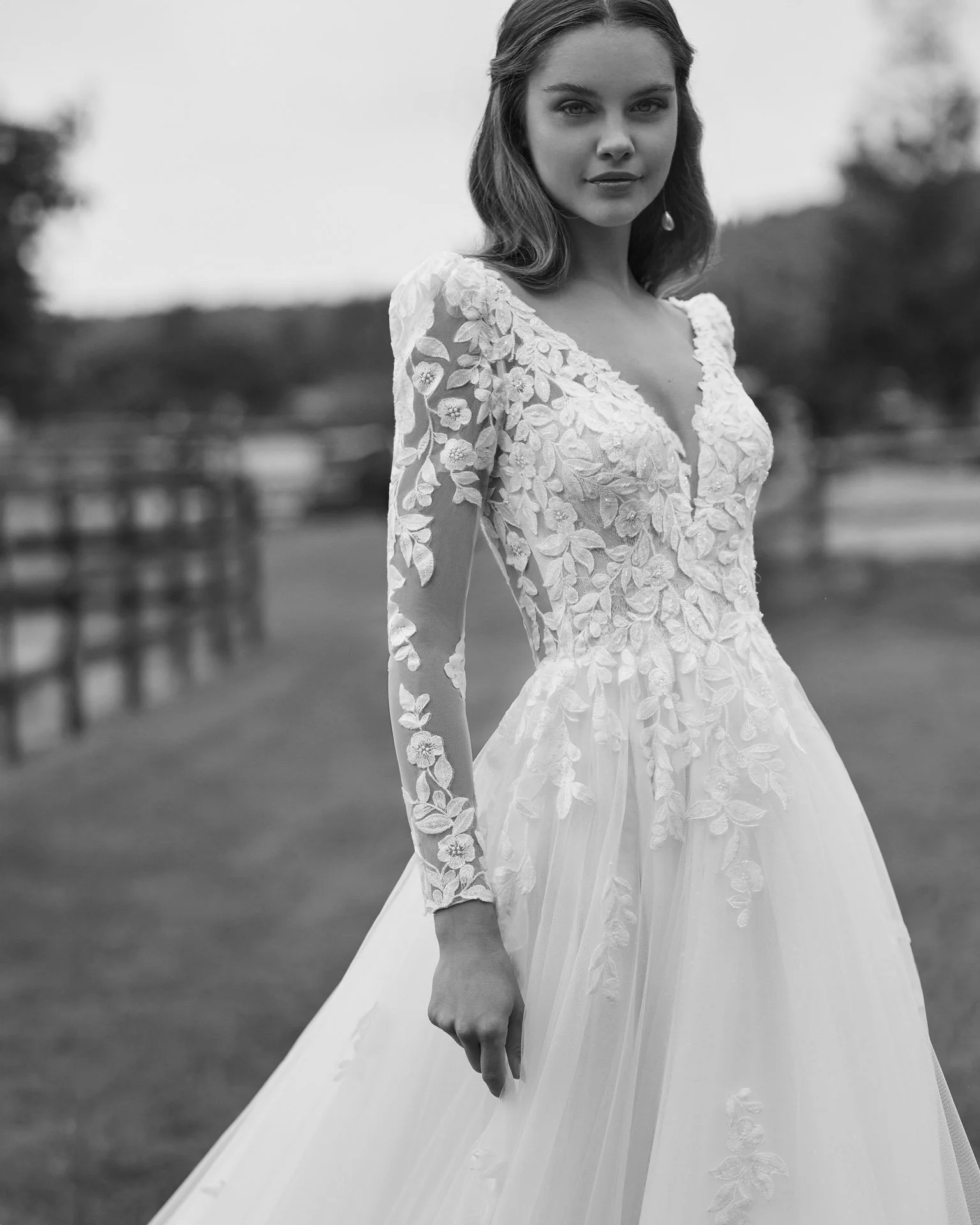Corpete rendado do vestido de noiva Nolir, com decote em V profundo, cintura bem definida e mangas compridas rendadas.