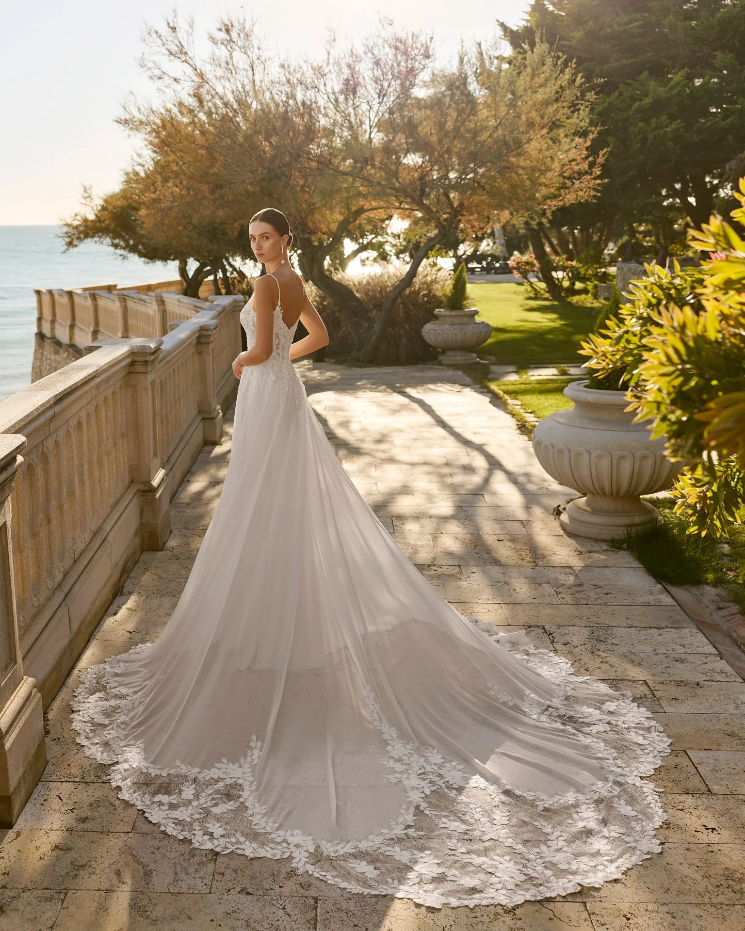 Vestido de noiva Feneya em chiffon, com decote em V nas costas, cintura estruturada, saia esvoaçante e cauda rendada.