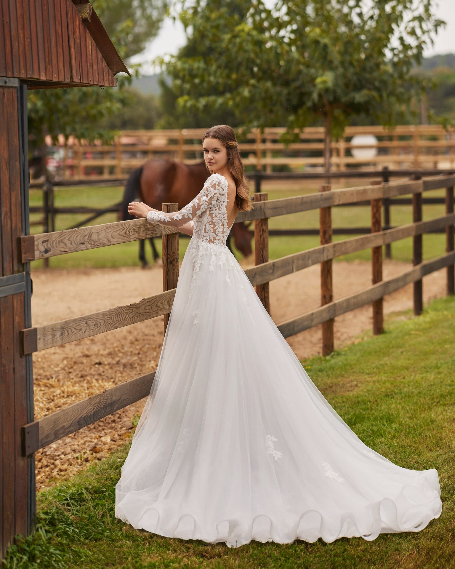 Vestido de noiva Nolir de corte em A, com decote em V profundo nas costas, mangas compridas rendadas e saia em tule com aplicações de renda.
