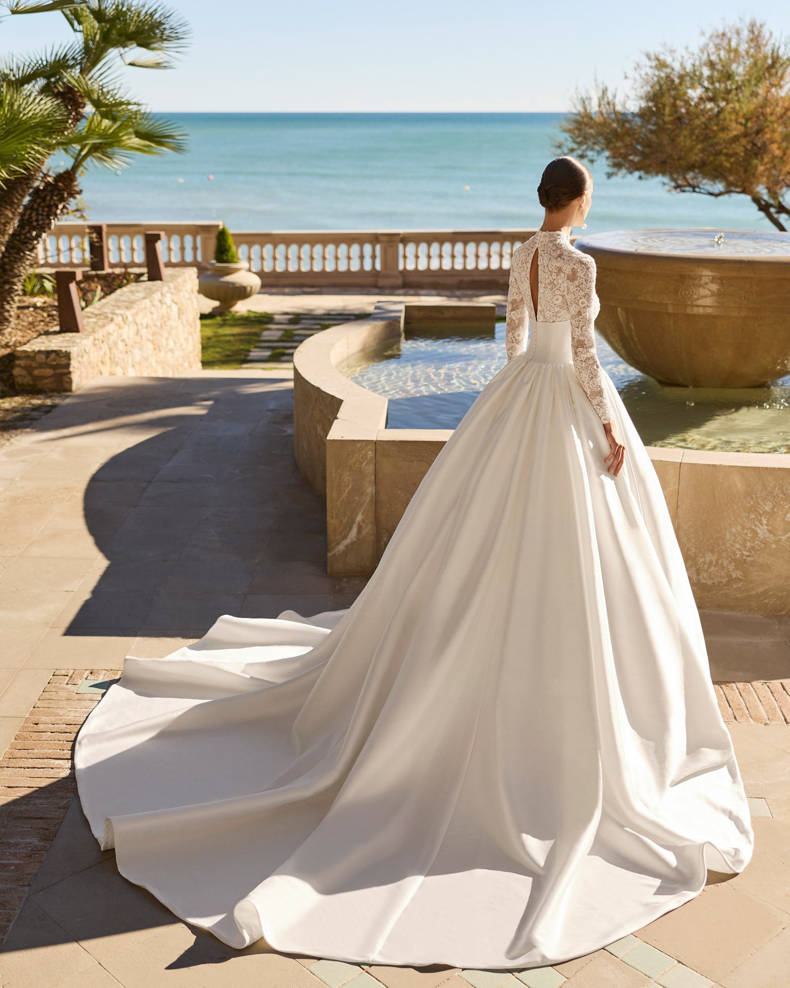 Vestido de noiva Frisa de corte princesa, com mangas compridas, decote em lágrima nas costas e saia volumosa com pregas e bolsos.