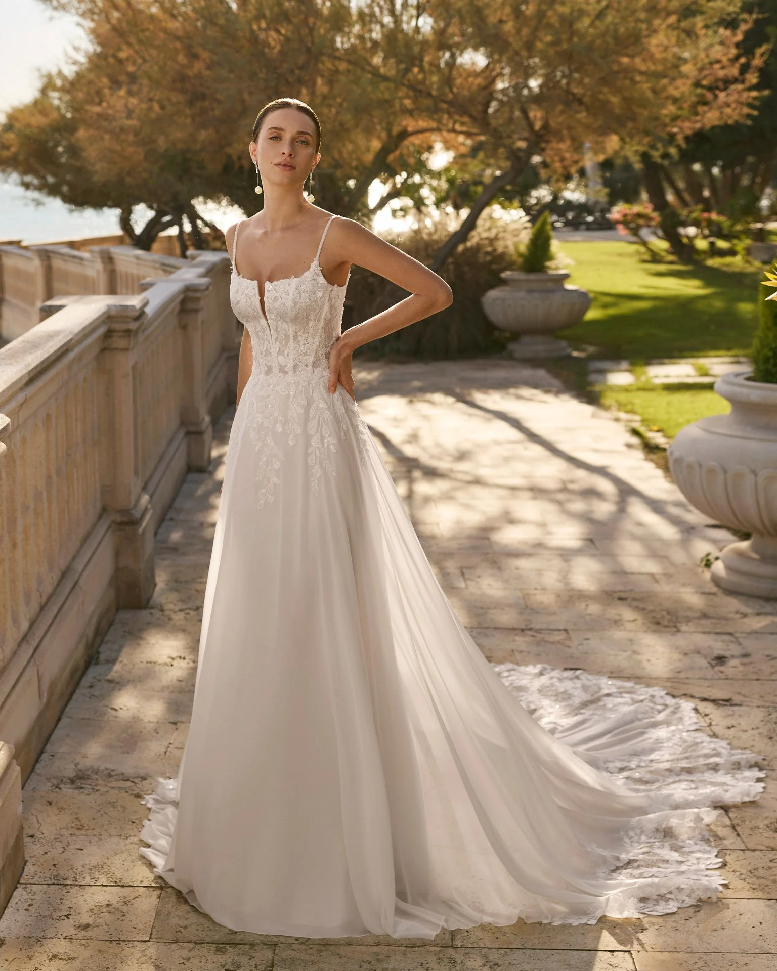Vestido de noiva Feneya de corte esvoaçante em chiffon, com corpete em rendas delicadas, pequena pedraria, cintura estruturada e decote quadrado com V profundo.