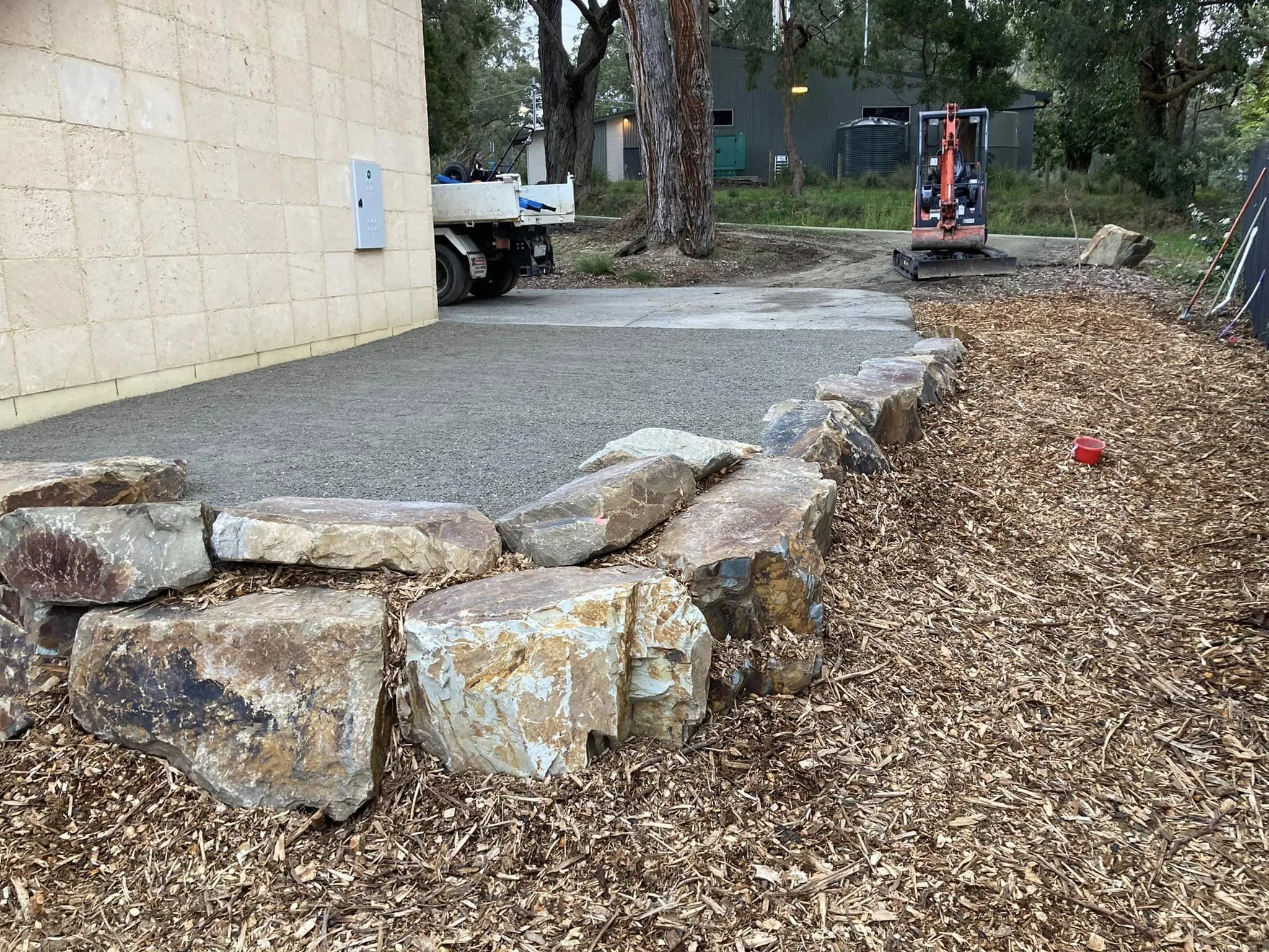 Rock retaining wall and compacted driveway