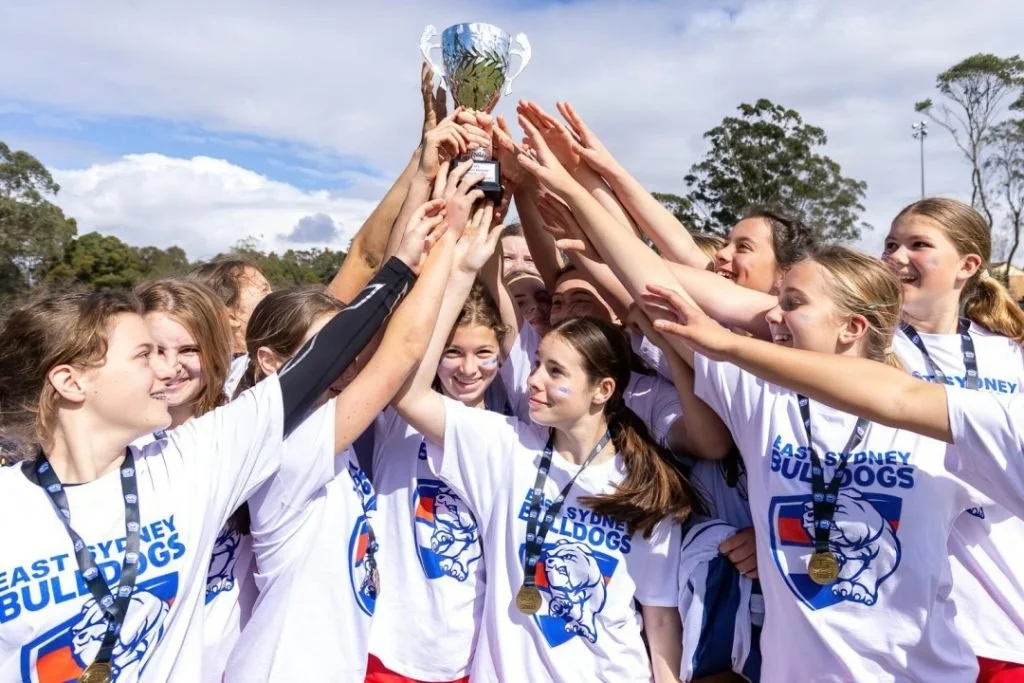 junior-womens-football-team-holding-trophy-celebrating